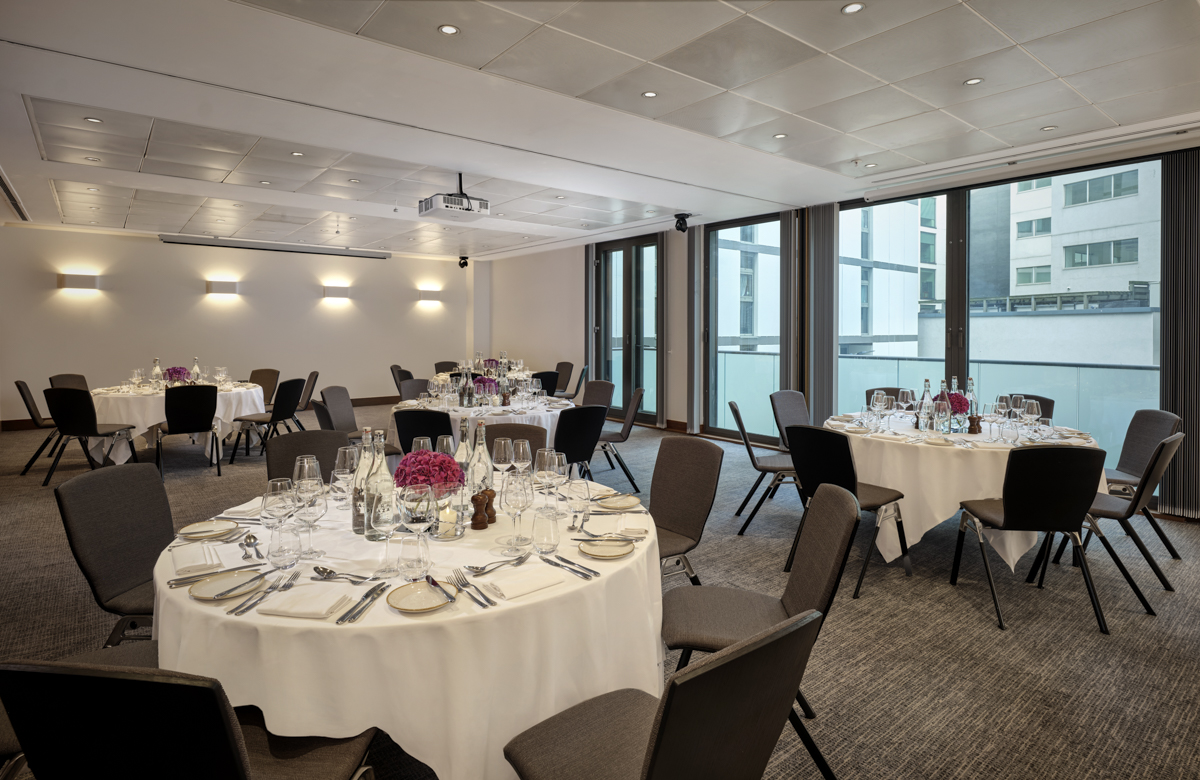 Putney Suite event space with round tables, ideal for corporate meetings and elegant dinners.