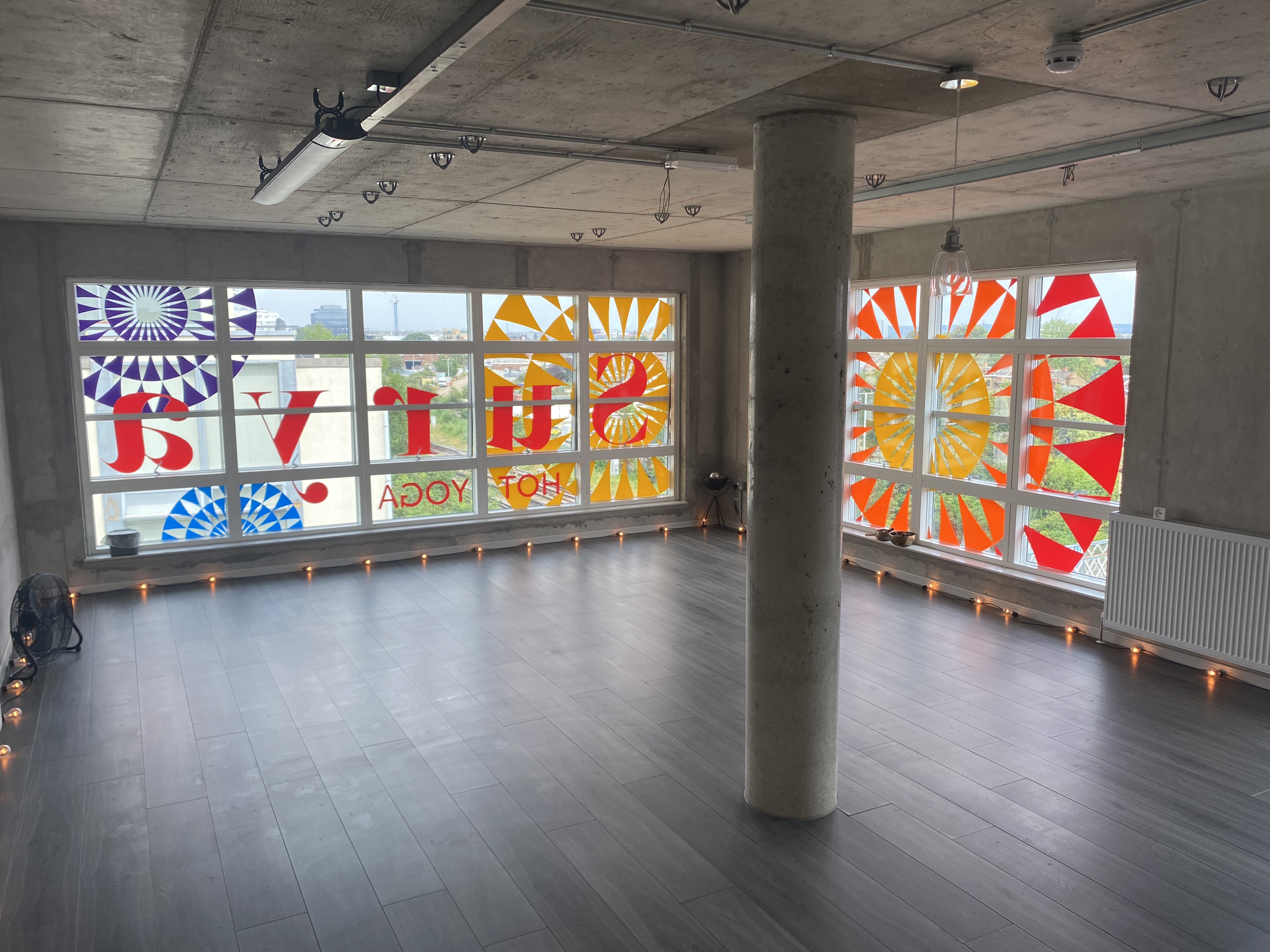 Spacious Surya Studio 2 with colorful windows, perfect for yoga classes and workshops.