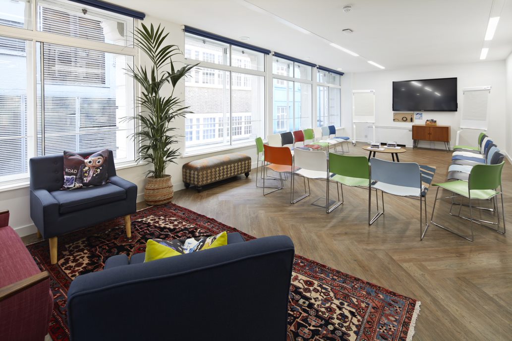 Modern meeting space with colorful chairs, ideal for workshops and brainstorming sessions.