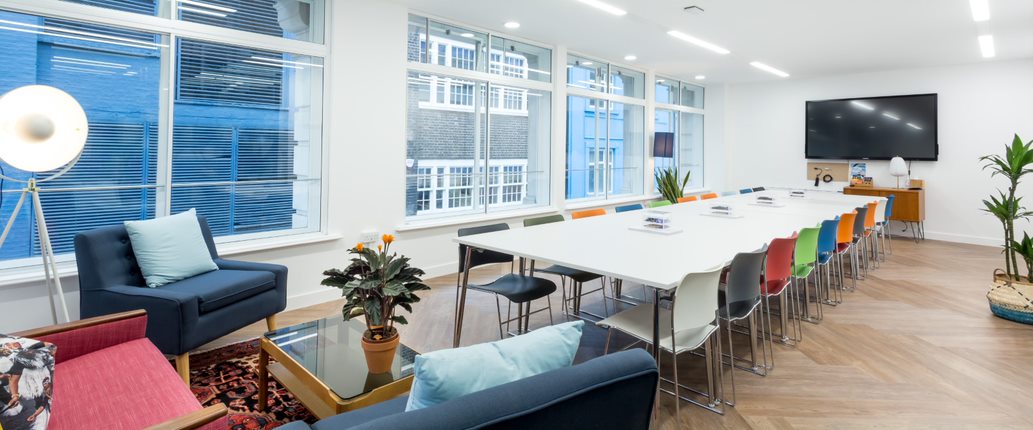 Modern meeting room with colorful chairs, ideal for collaboration and brainstorming events.