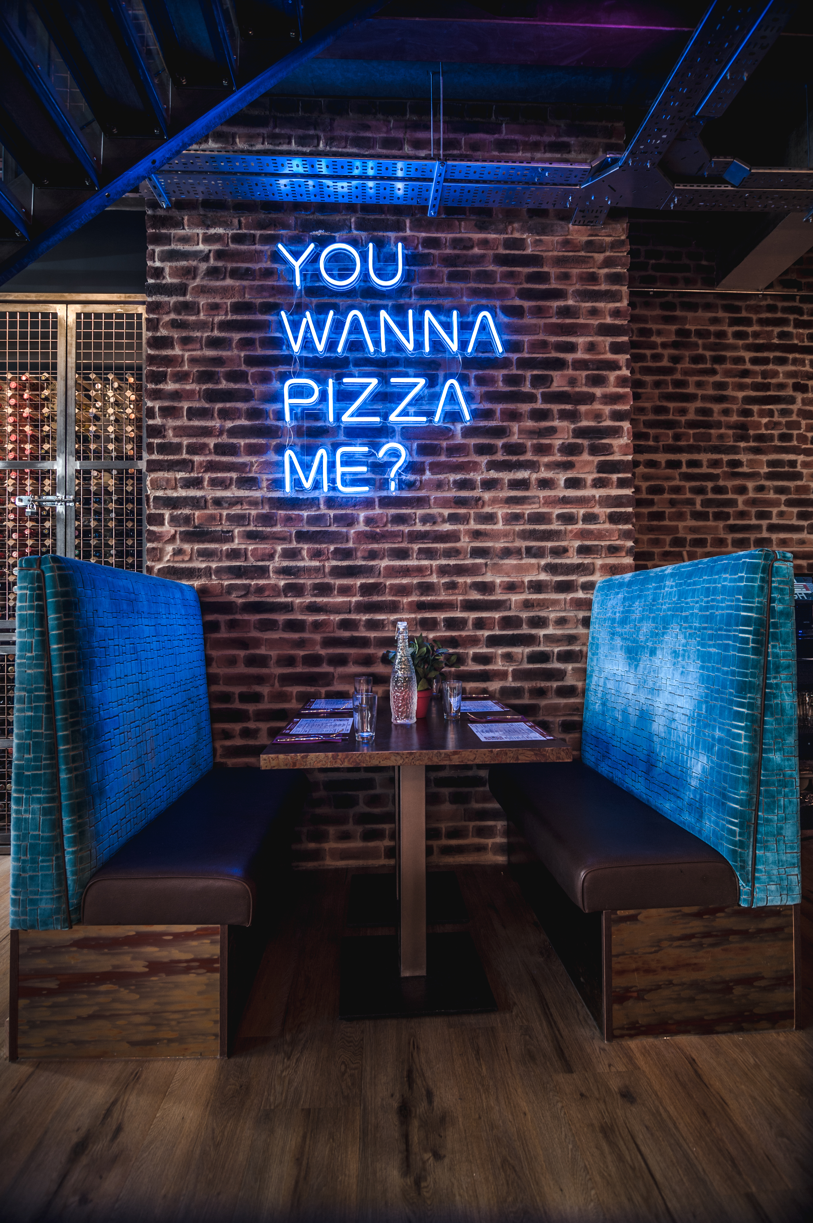 Cozy dining space at Dough Dough Liverpool with neon sign, perfect for casual gatherings.