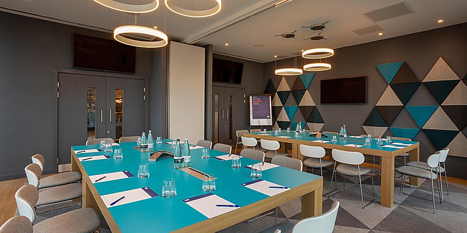 Modern meeting room with turquoise tables at Holiday Inn Express Bridgwater for workshops.