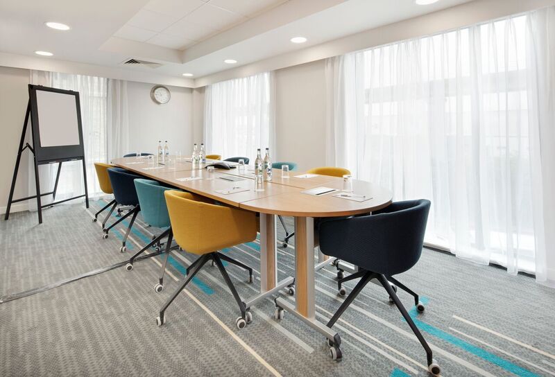 Modern meeting room with ergonomic chairs at Hampton by Hilton London Docklands, ideal for workshops.
