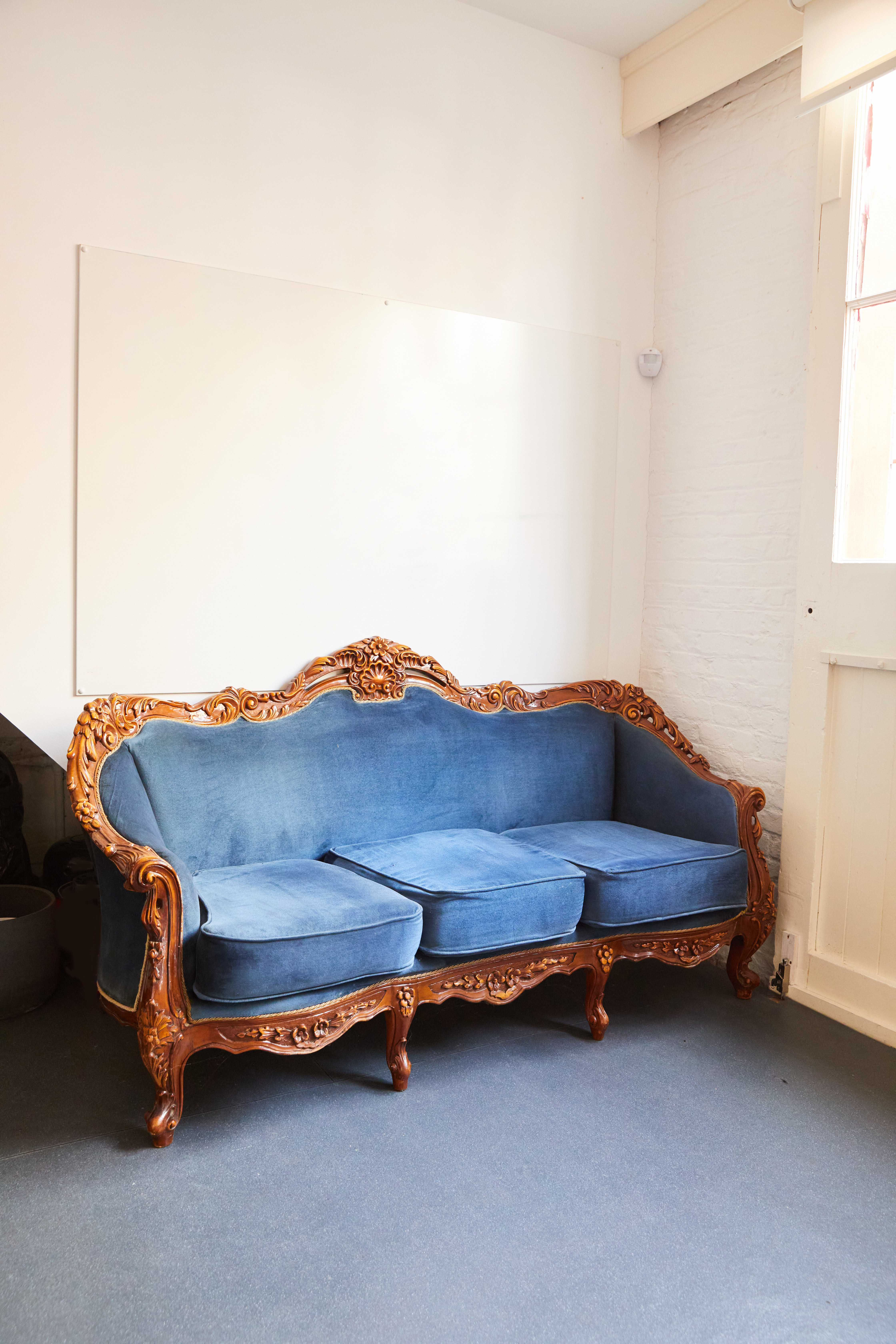 Vintage blue velvet sofa with ornate detailing at Bright Banana Studios event venue.