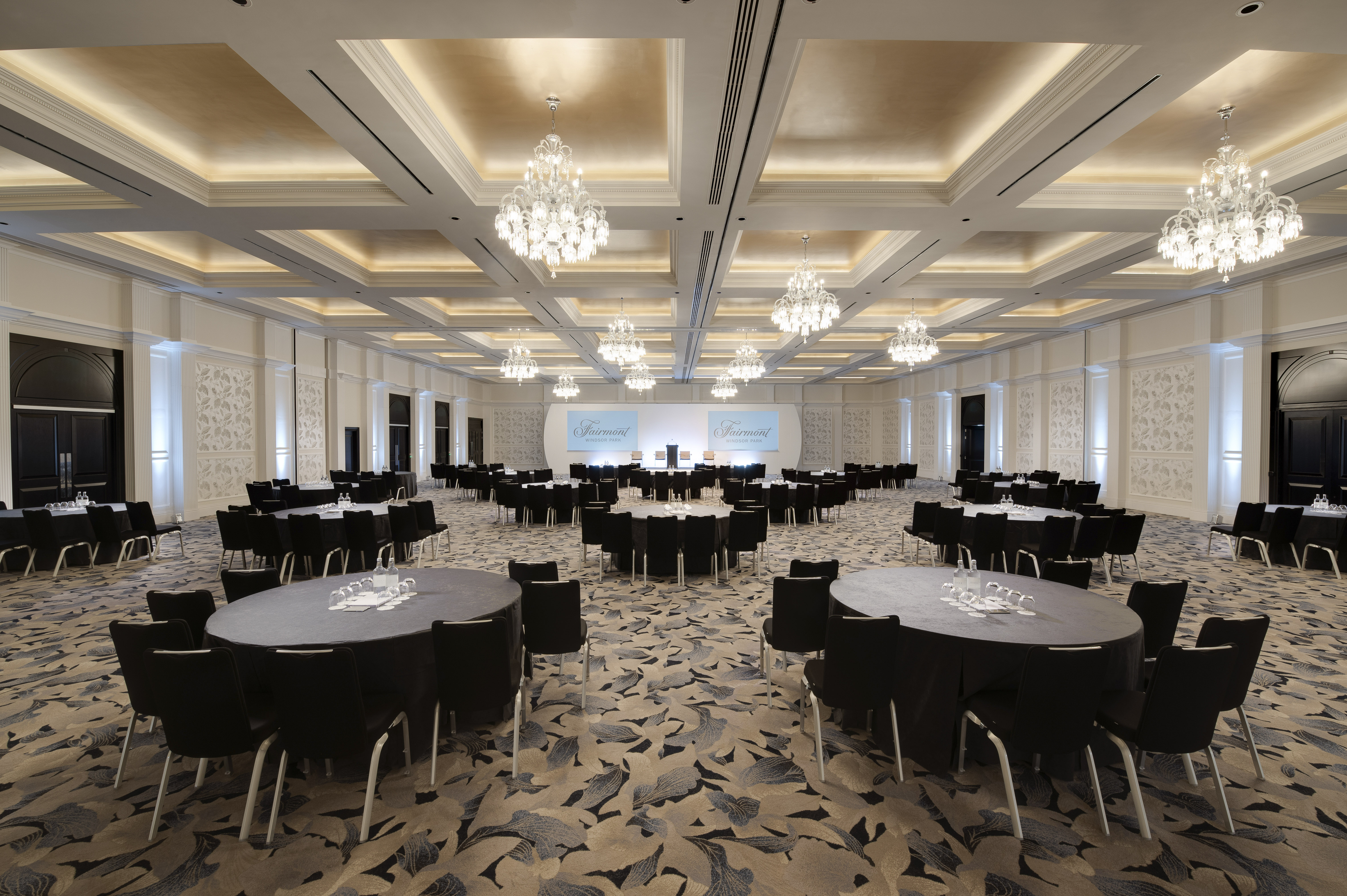 Arora Ballroom at Fairmont Windsor Park, elegant conference venue with round tables.