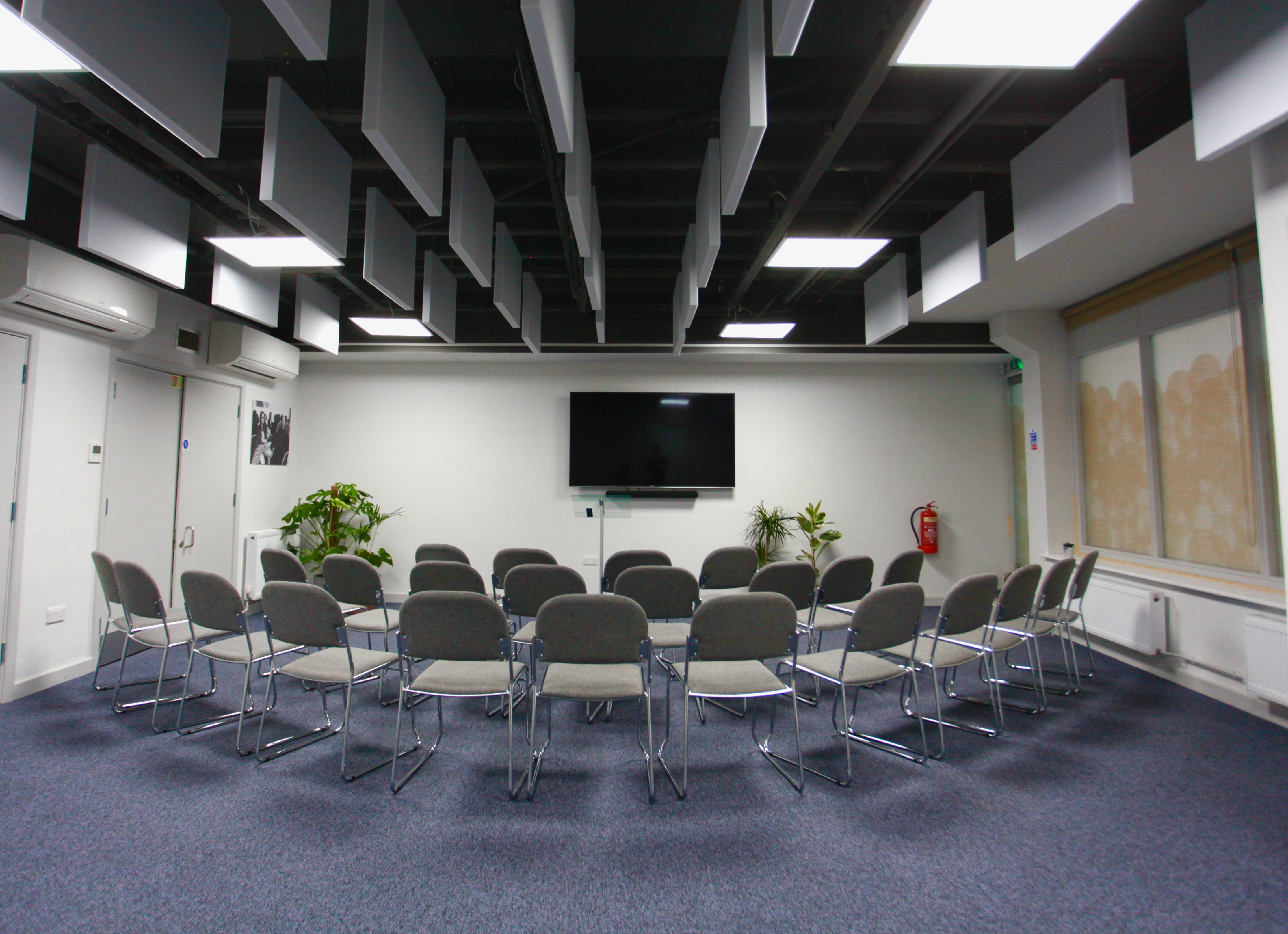 Meeting room at Neal Street Espresso with chairs and screen for workshops and presentations.