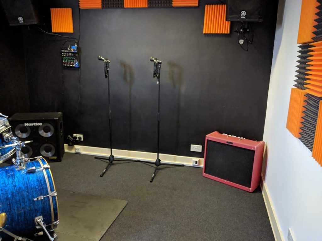 Rehearsal space with audio gear, ideal for music events and presentations.