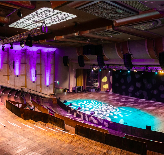 Spacious Theatre in EartH with vibrant lighting for concerts and corporate events.