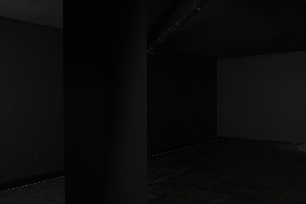 Minimalist dimly lit venue in Blackout studio for versatile events and gatherings.