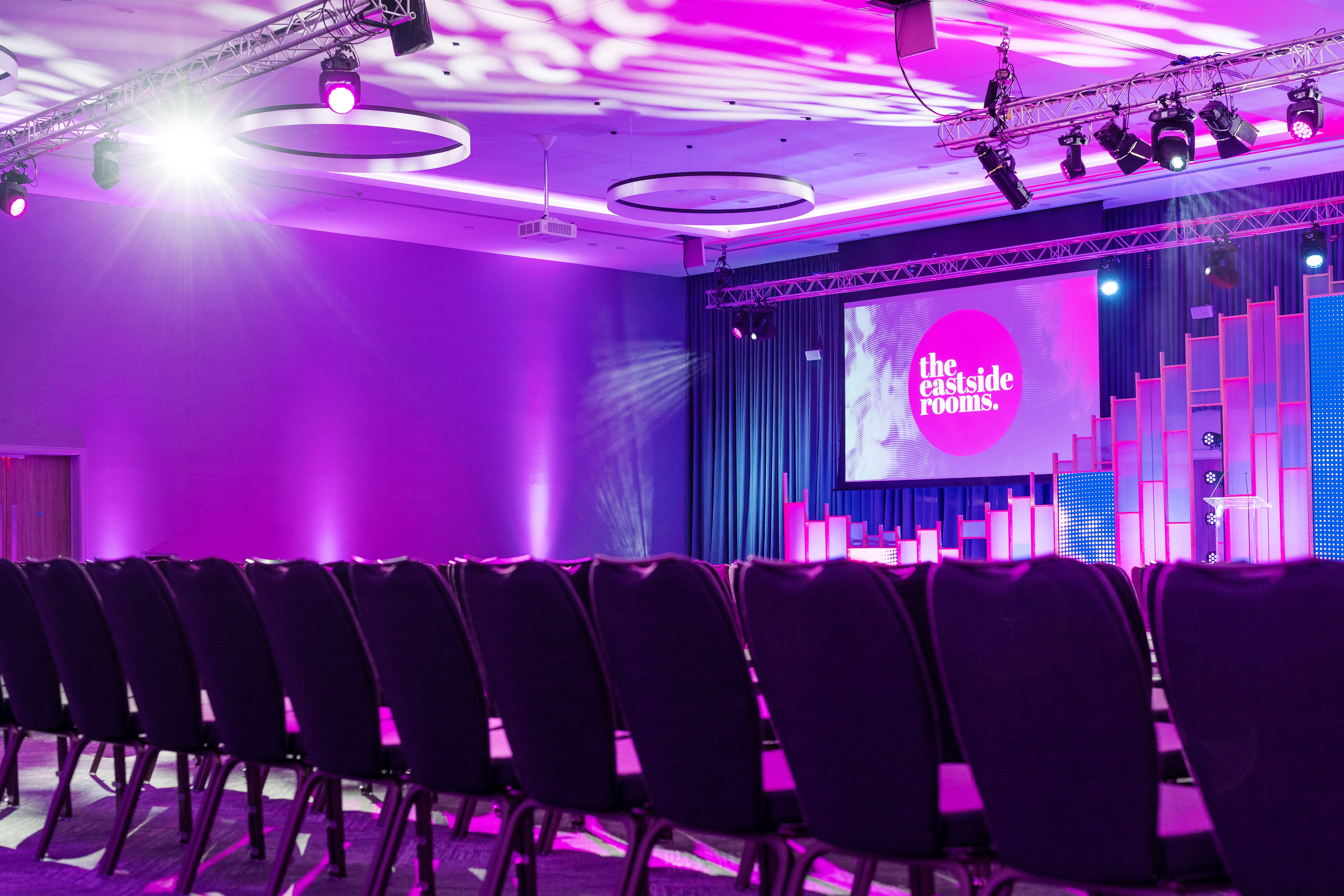 Affinity Two conference space with elegant chairs and vibrant stage, perfect for events.