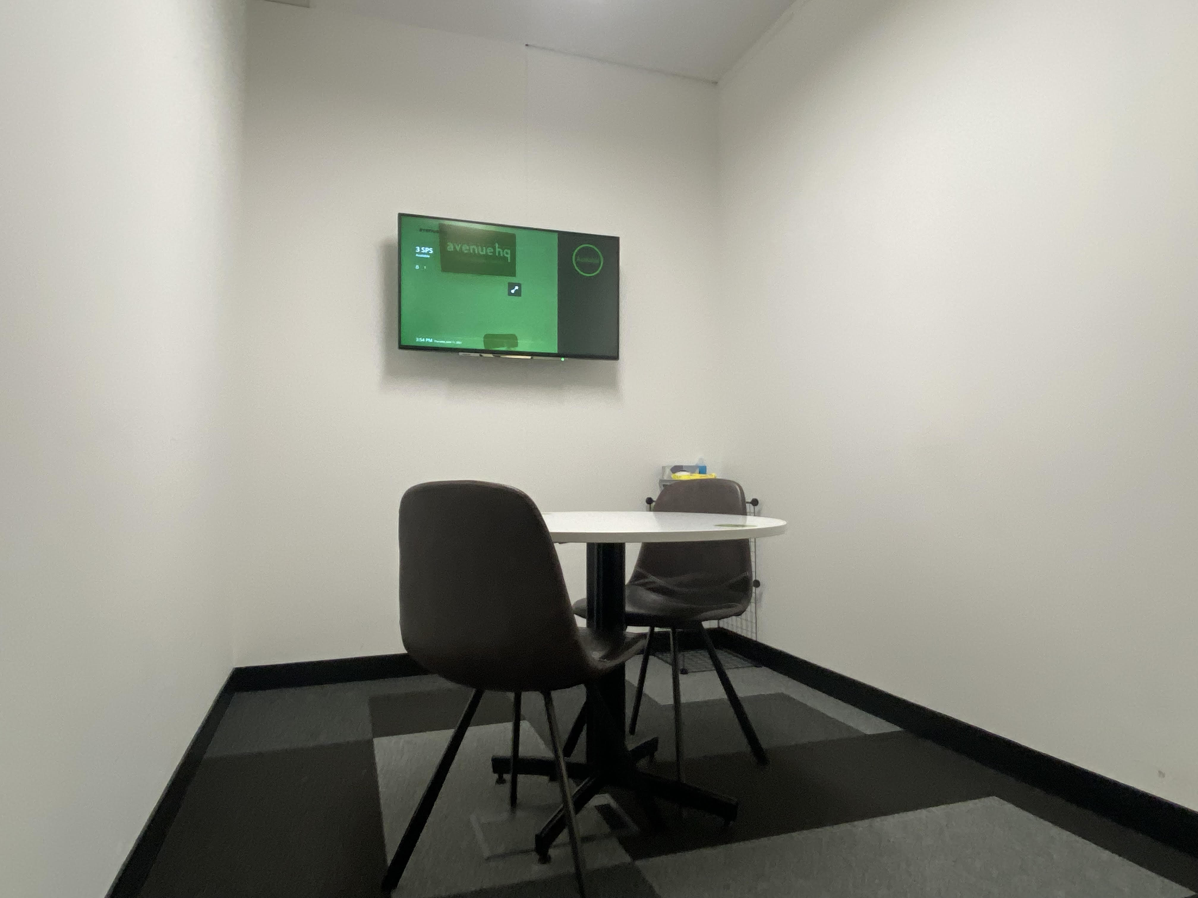 Modern meeting room at SPS3, featuring a wall-mounted screen for focused discussions.