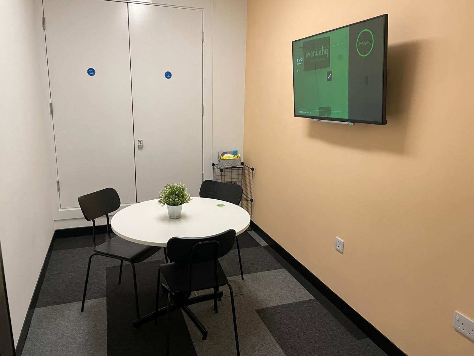 Small meeting room with round table, ideal for brainstorming sessions and presentations.