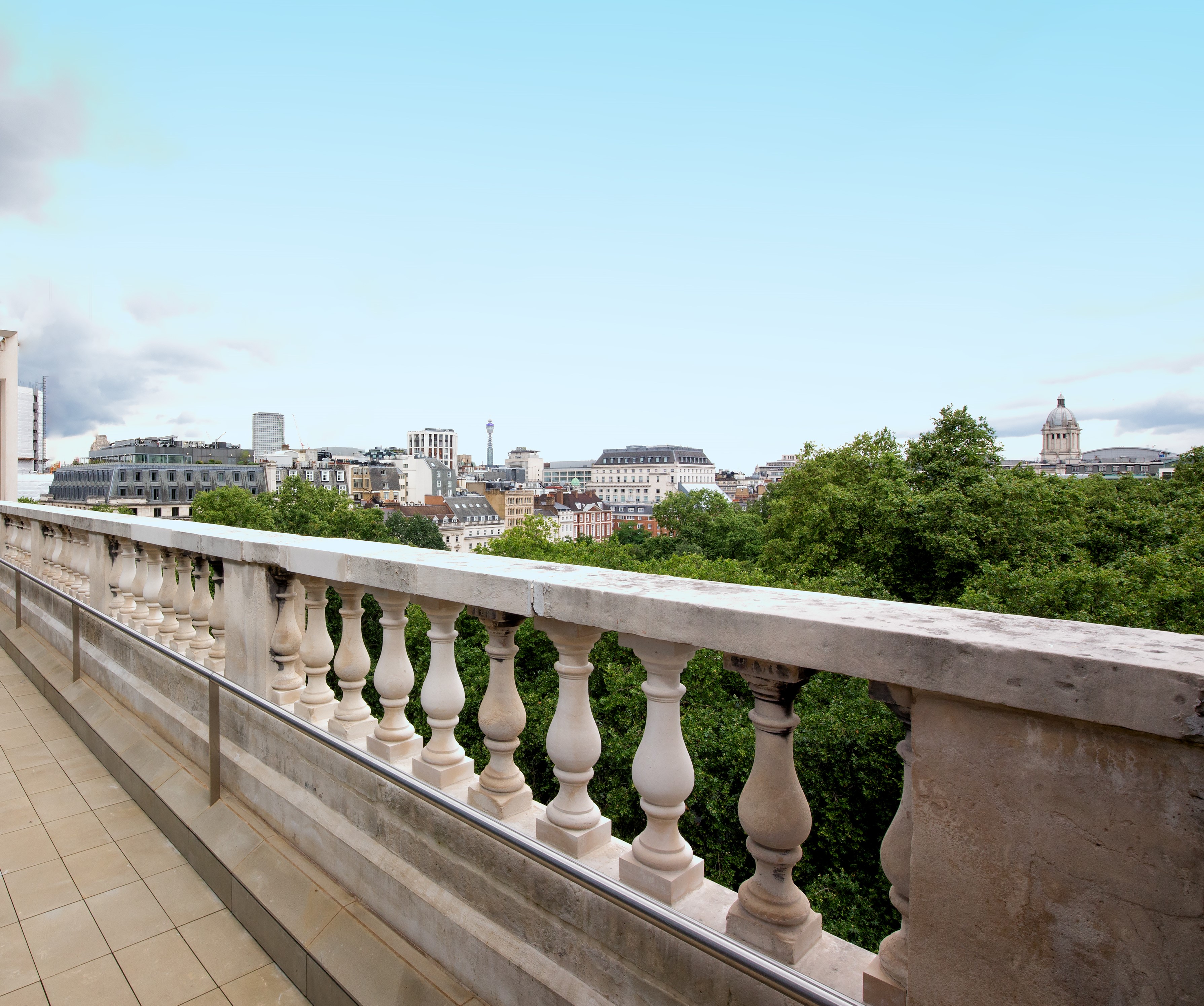 Stunning urban balcony view with greenery, perfect for outdoor receptions and networking events.