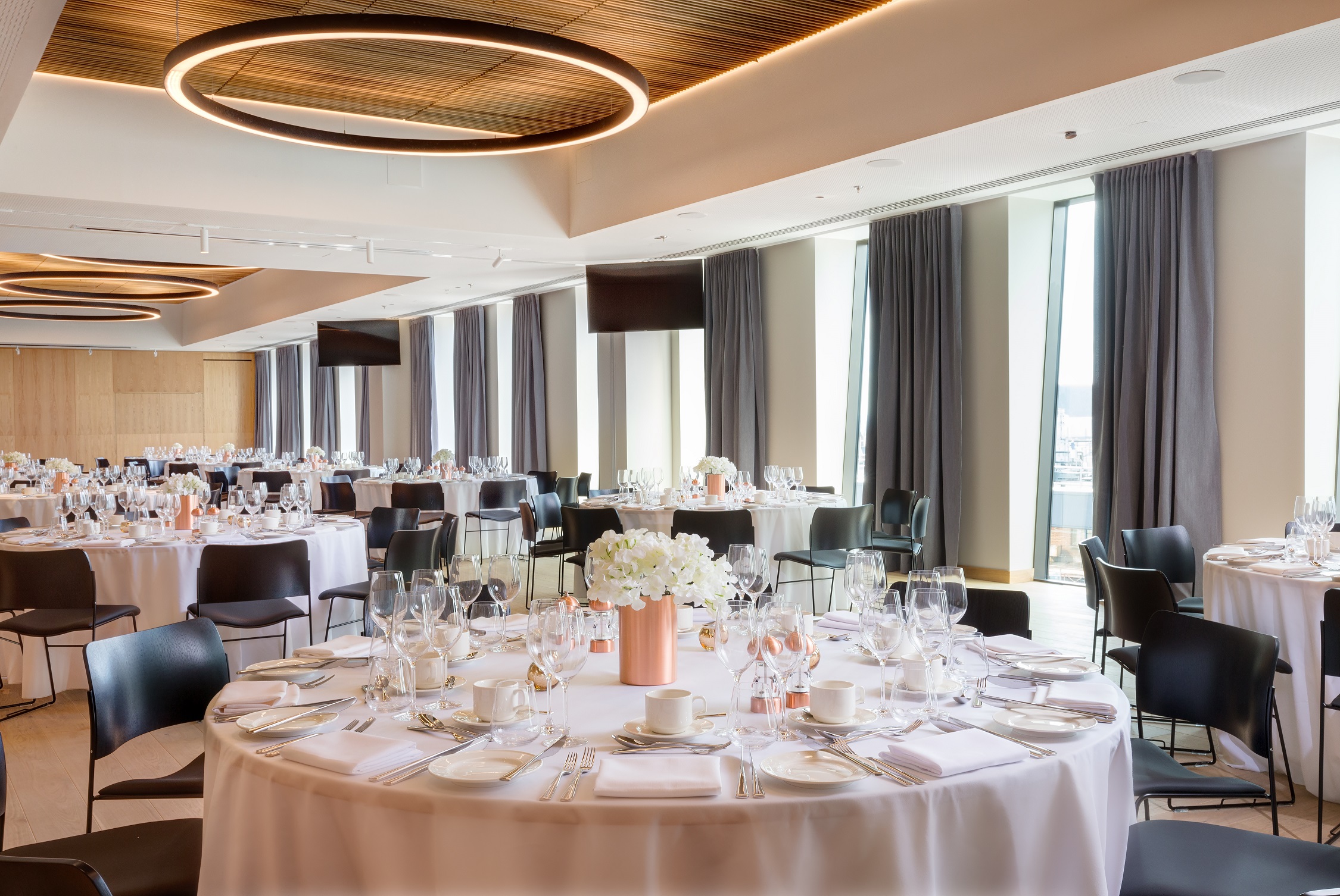 Elegant event space with round tables, perfect for corporate gatherings and upscale celebrations.