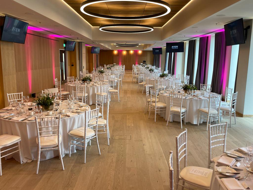 Elegant banquet hall, round tables, floral centerpieces, corporate event, wedding reception