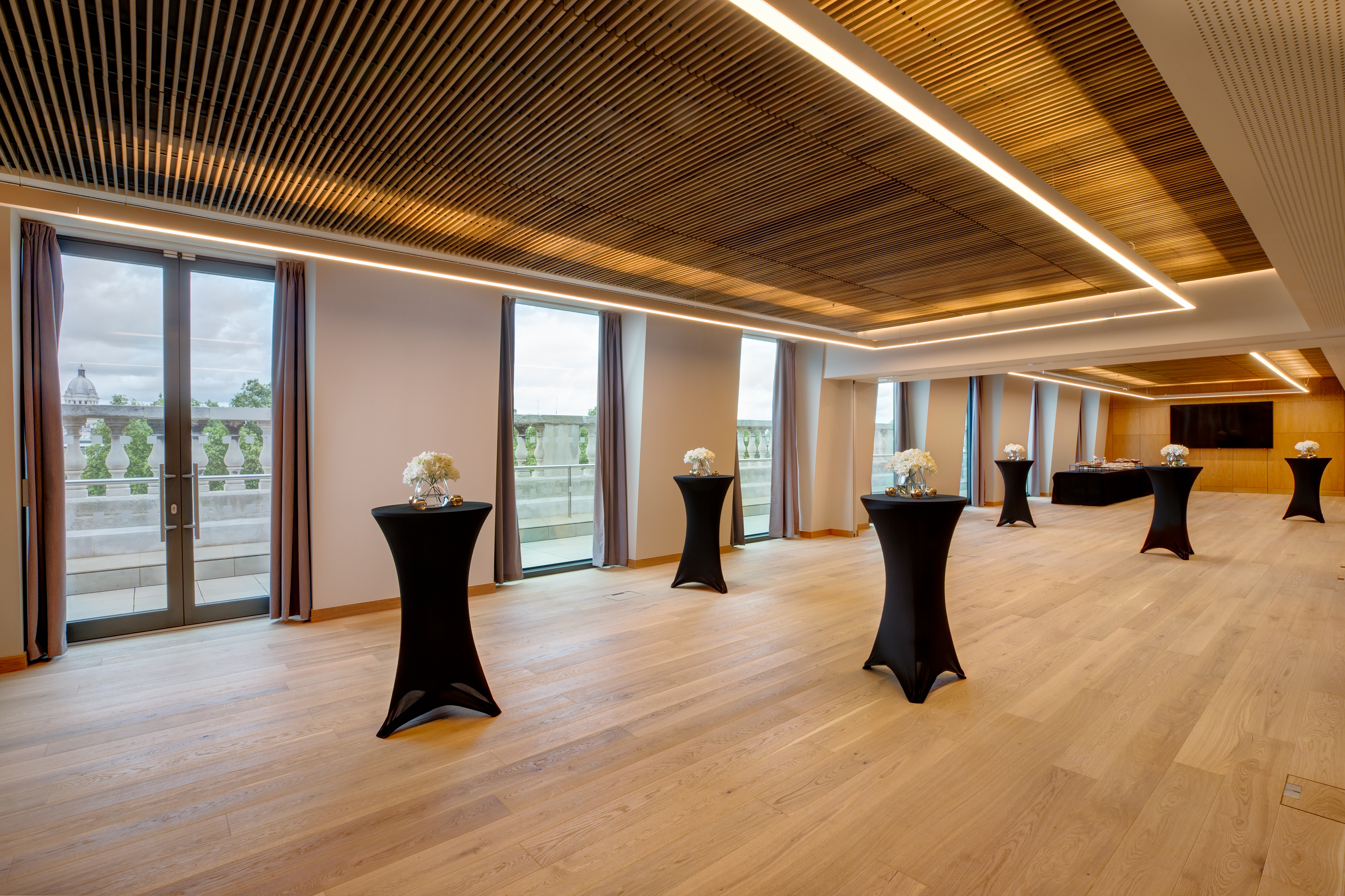 Modern event space with black cocktail tables, ideal for networking and receptions.
