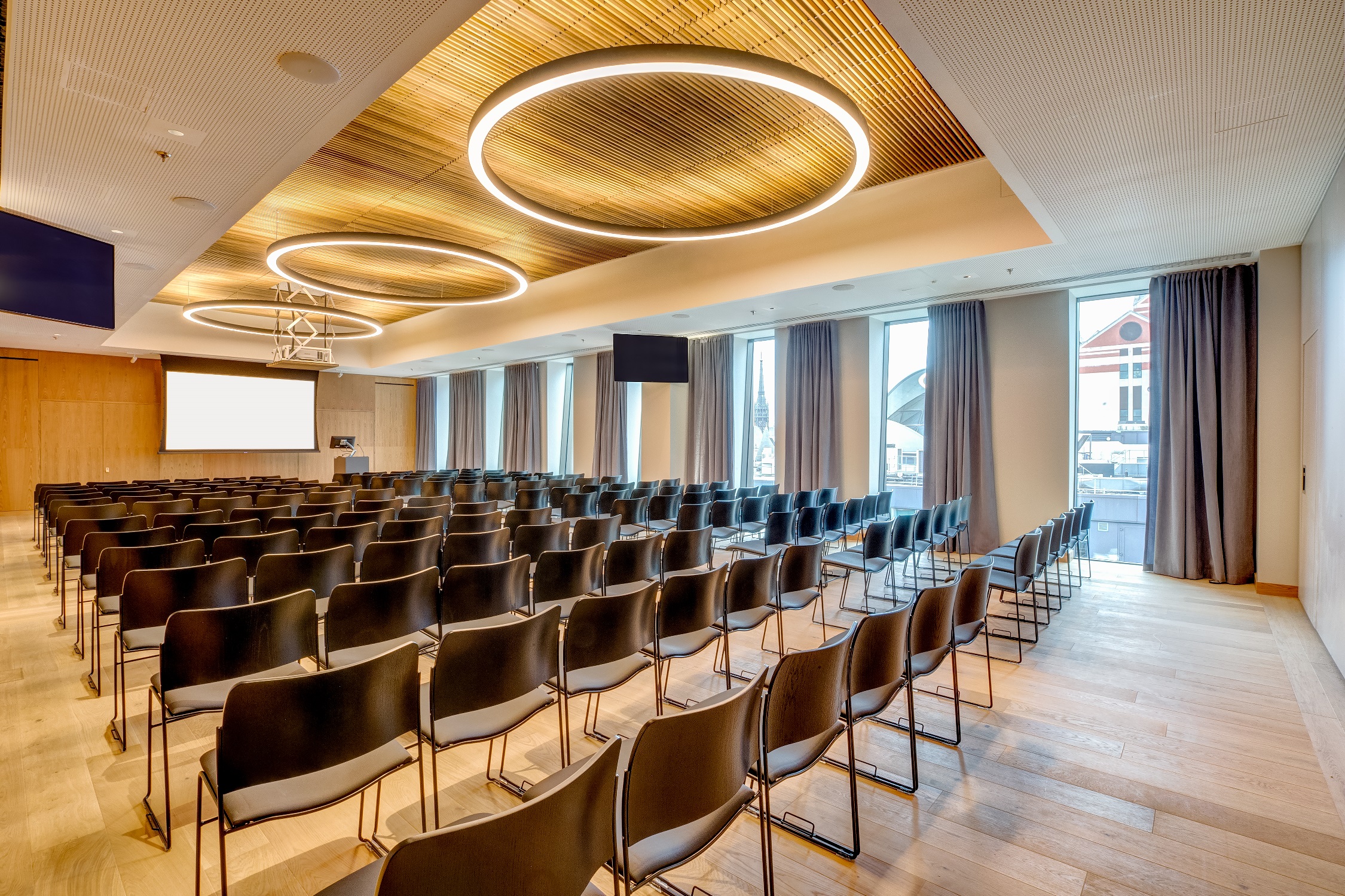 Modern event space with sleek black chairs, ideal for meetings and conferences.