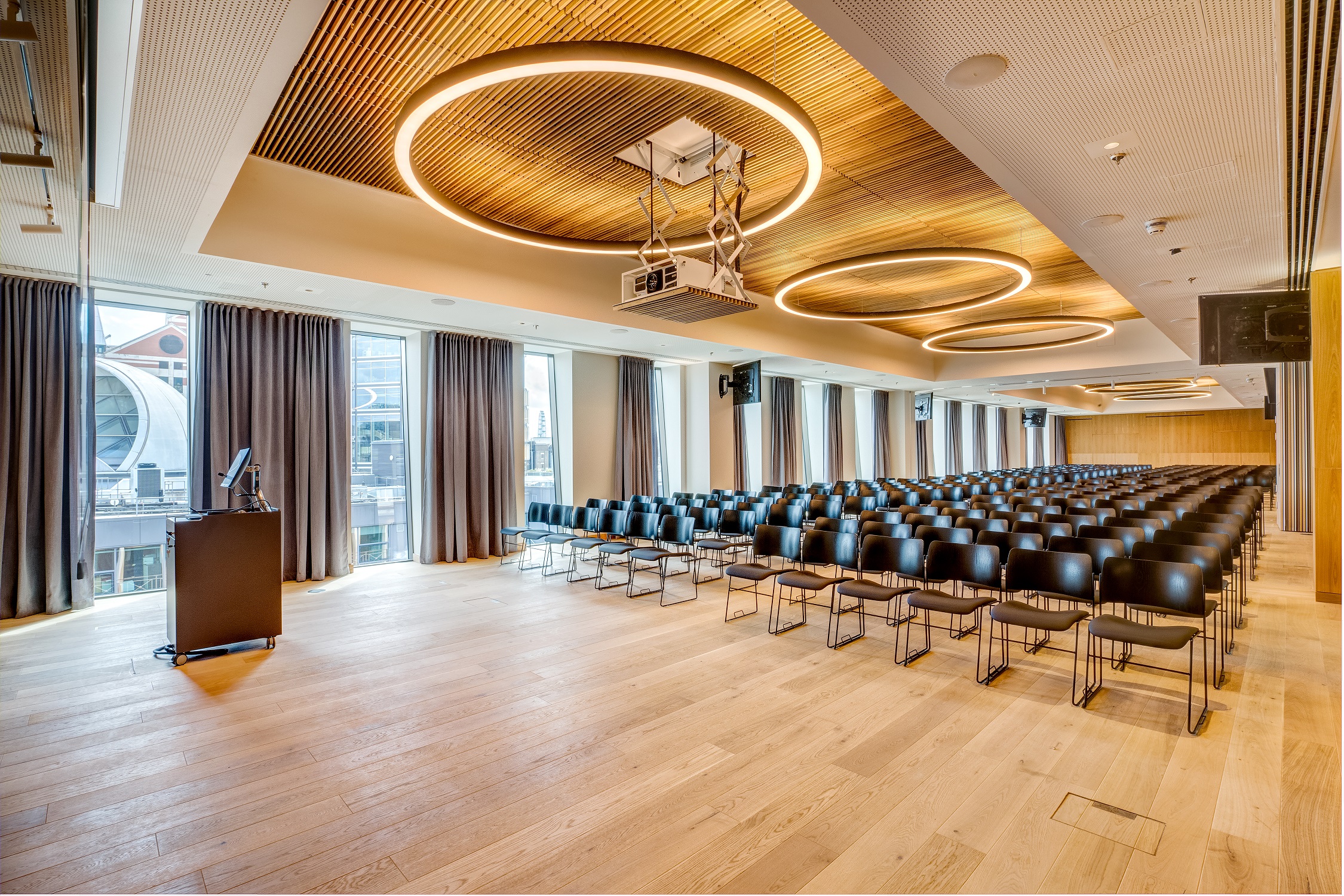 Modern event space with black chairs, ideal for corporate meetings and conferences.