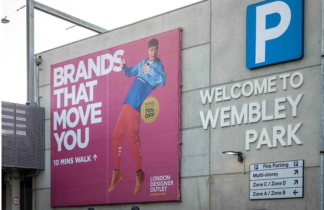 Vibrant advertisement at Pink Coach Park, Wembley Park for shopping and events.