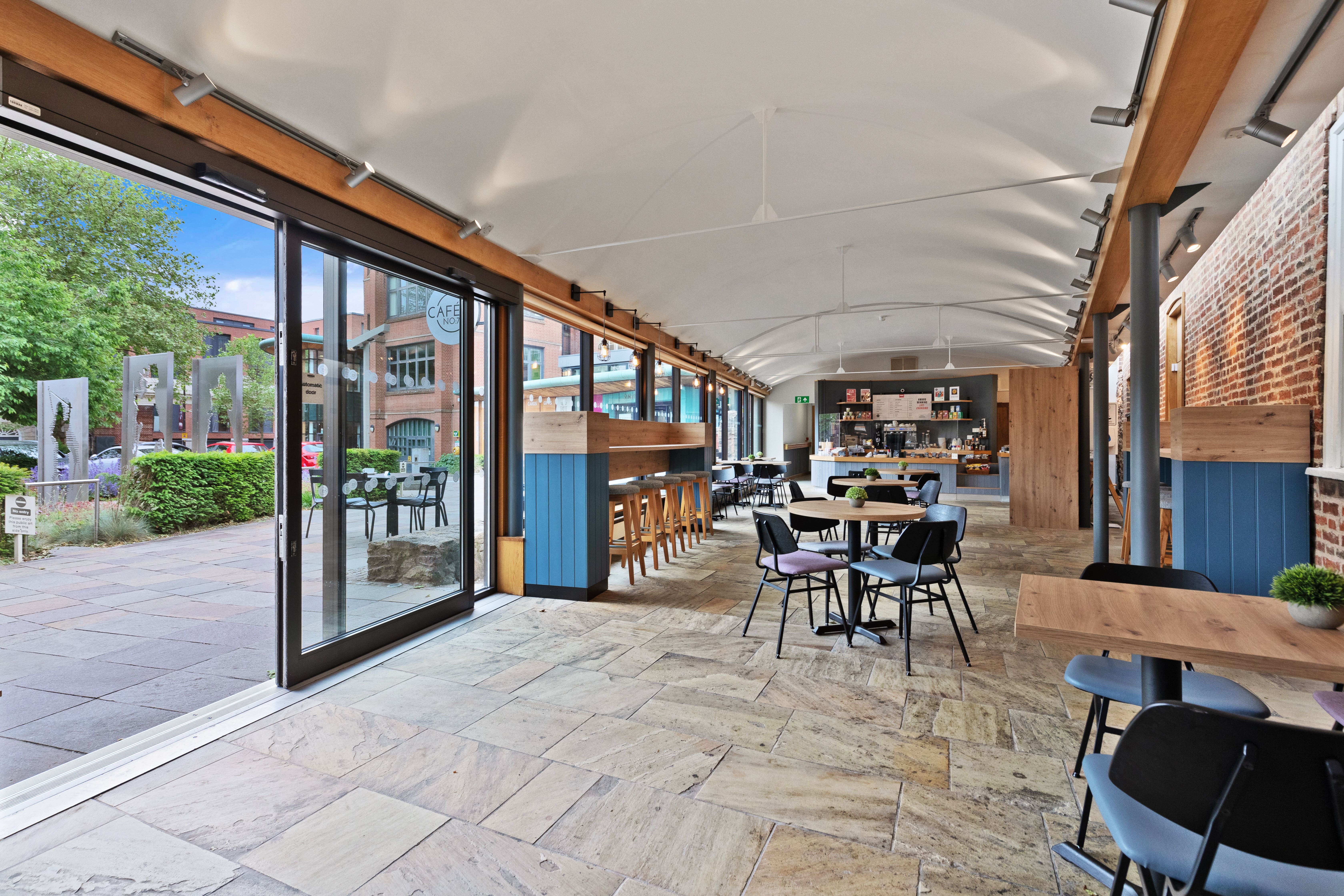 Modern event space with large windows at Cafe No:7, ideal for networking and workshops.