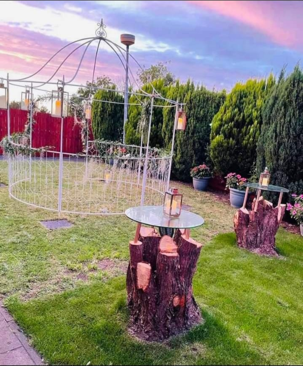 Wansbeck Suite outdoor wedding venue with rustic arch and tree stump tables.