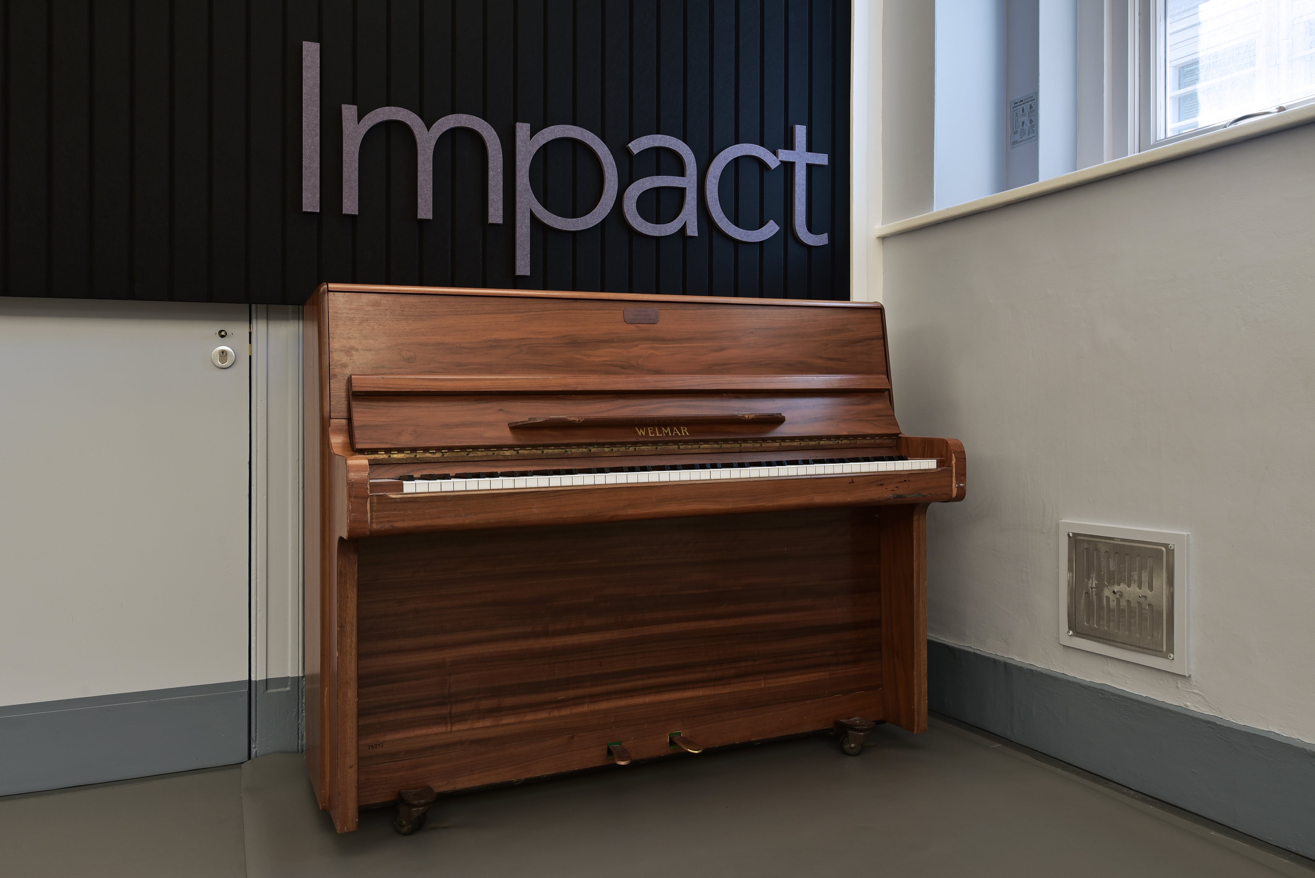 Polished wooden piano in Impact Dance Studio, ideal for networking events and creative sessions.