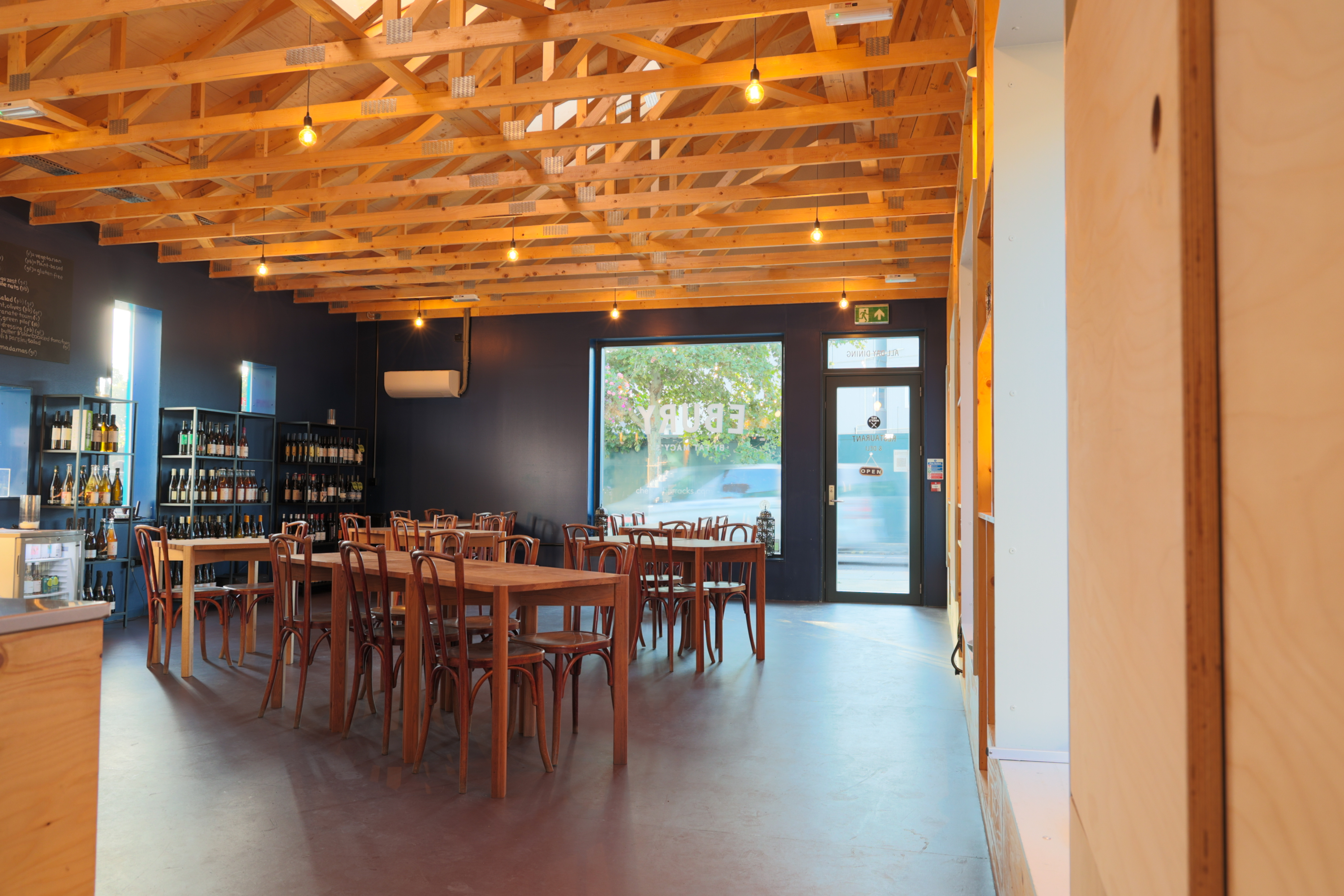 Modern wedding venue with wooden ceiling, ideal for receptions and workshops.