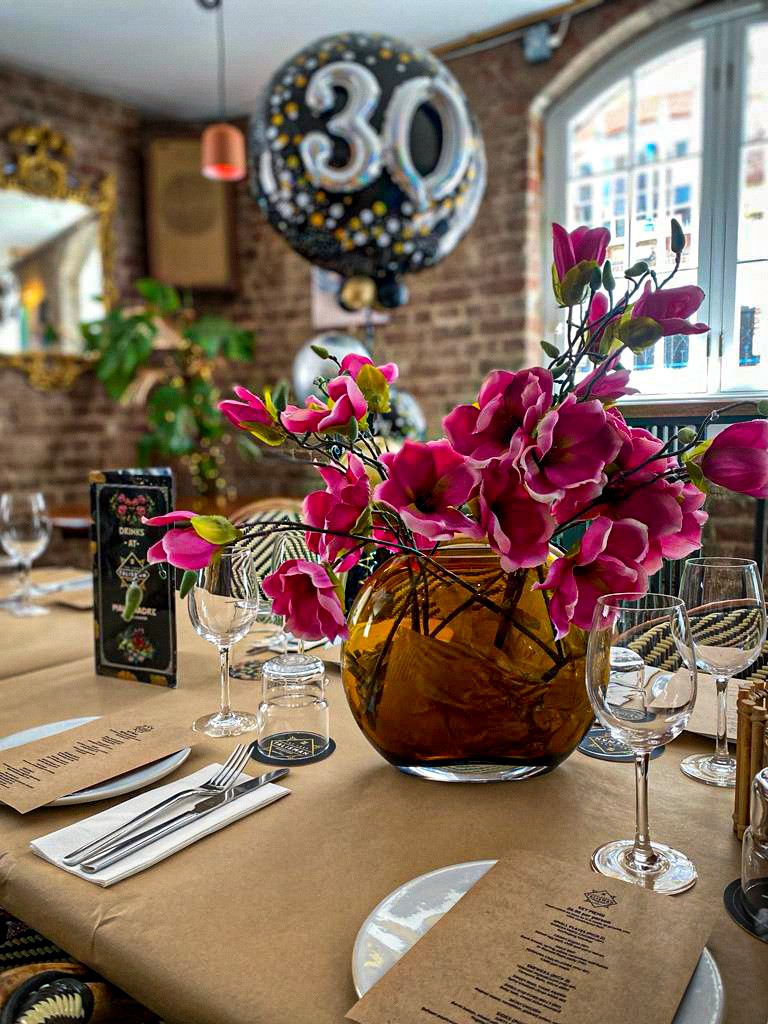 Elegant dining table with floral centerpiece at Mala Madre Private Events Space.