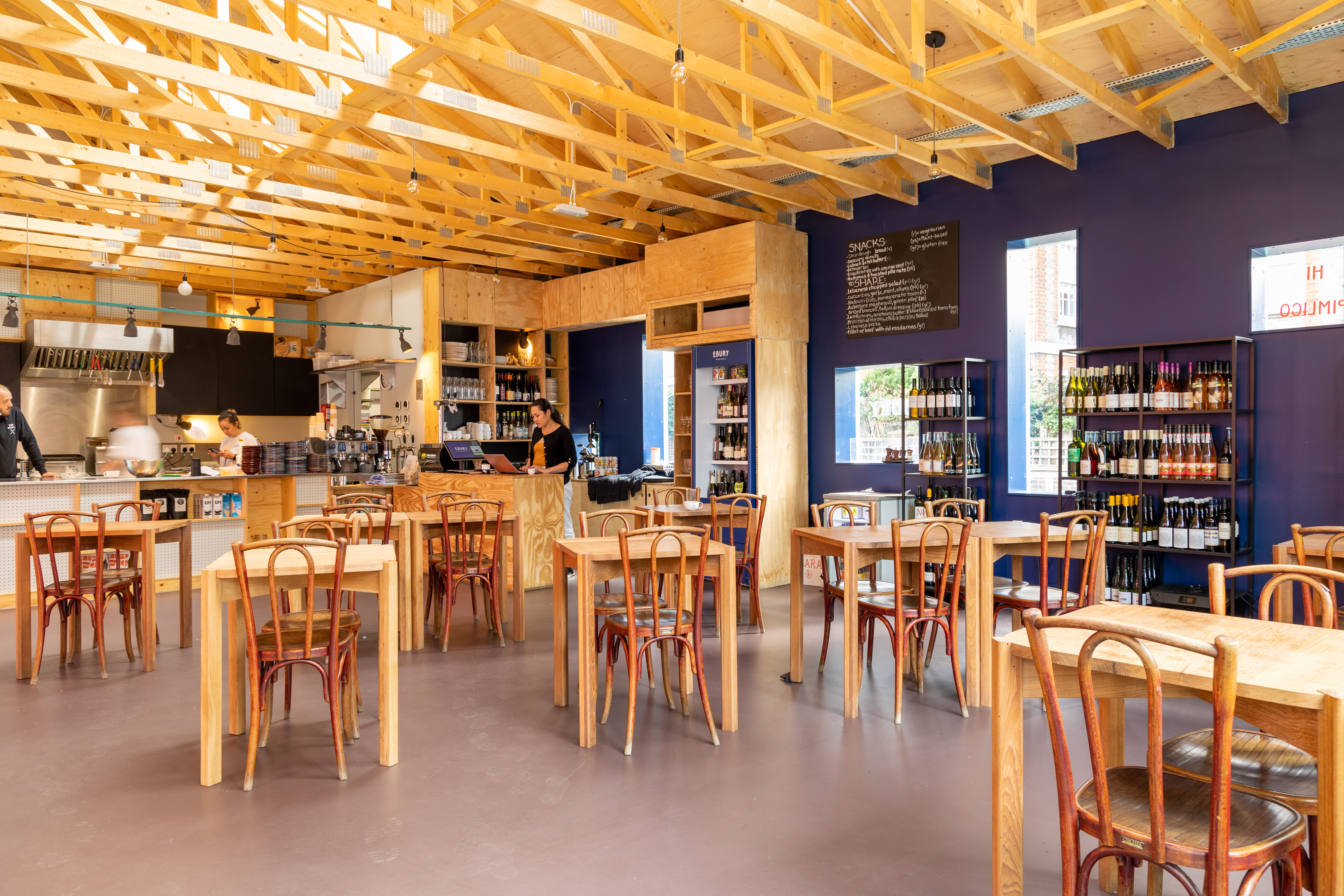 Modern restaurant courtyard with wooden seating, ideal for networking events and gatherings.