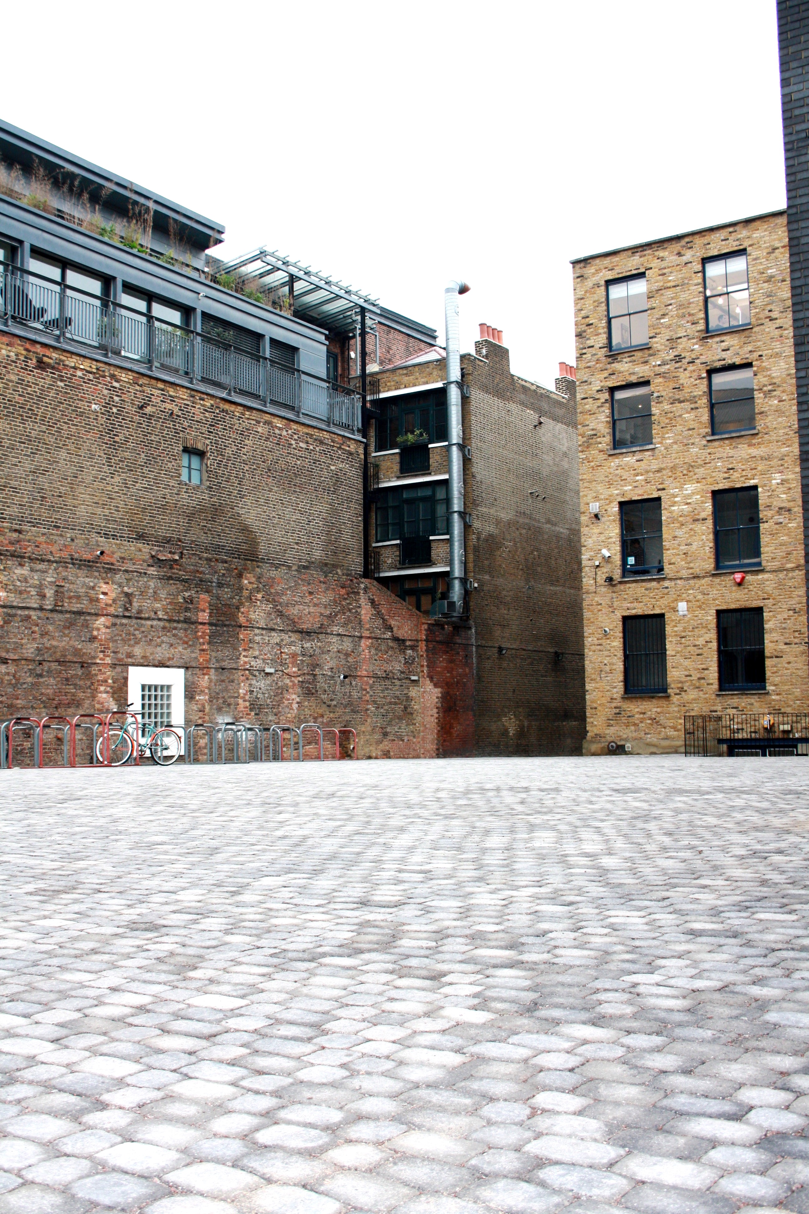 Courtyard in Shoreditch Electric, rustic brick walls, ideal for outdoor events and gatherings.