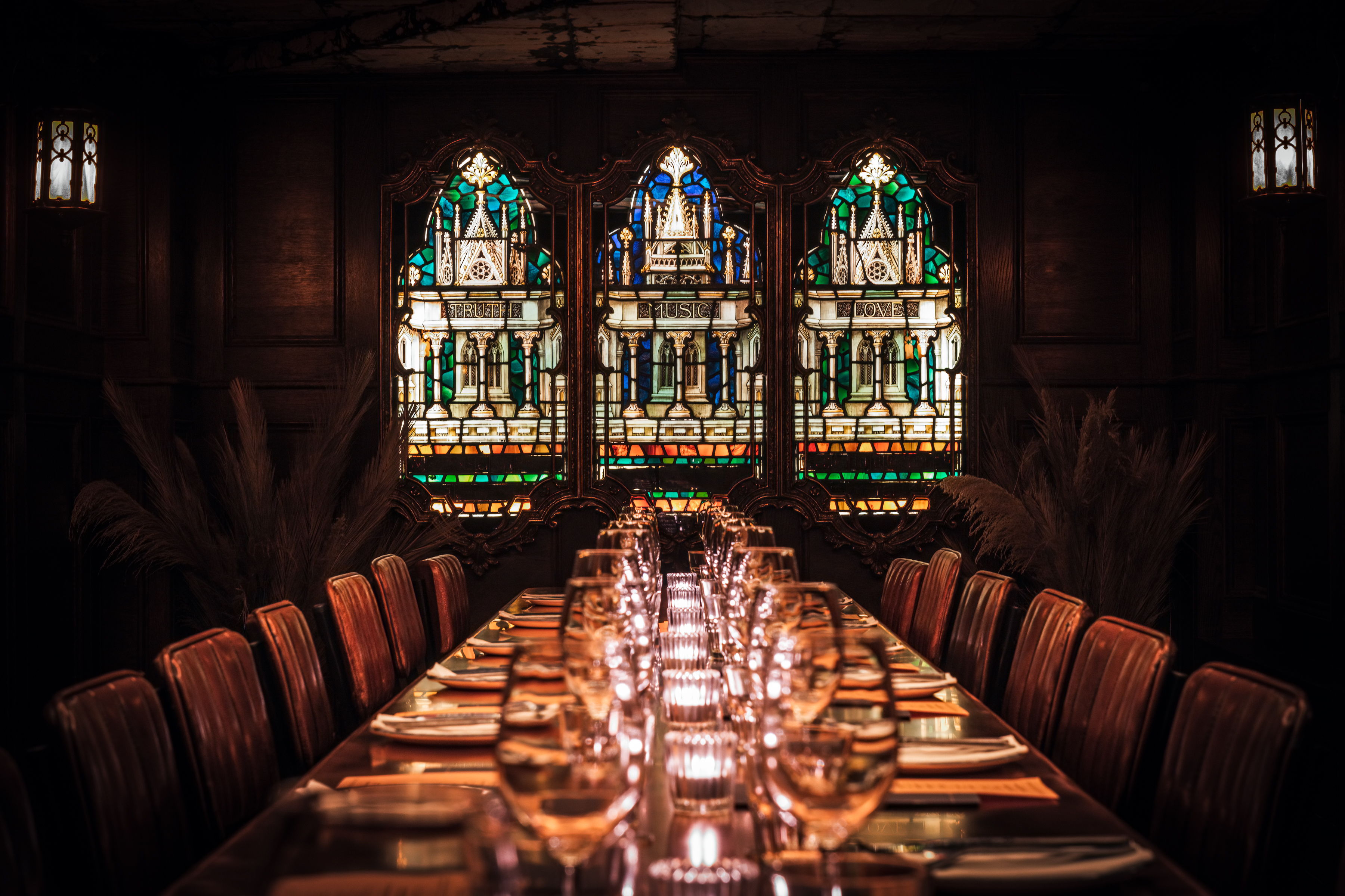 Private dining room with elegant table and stained glass, ideal for corporate events.