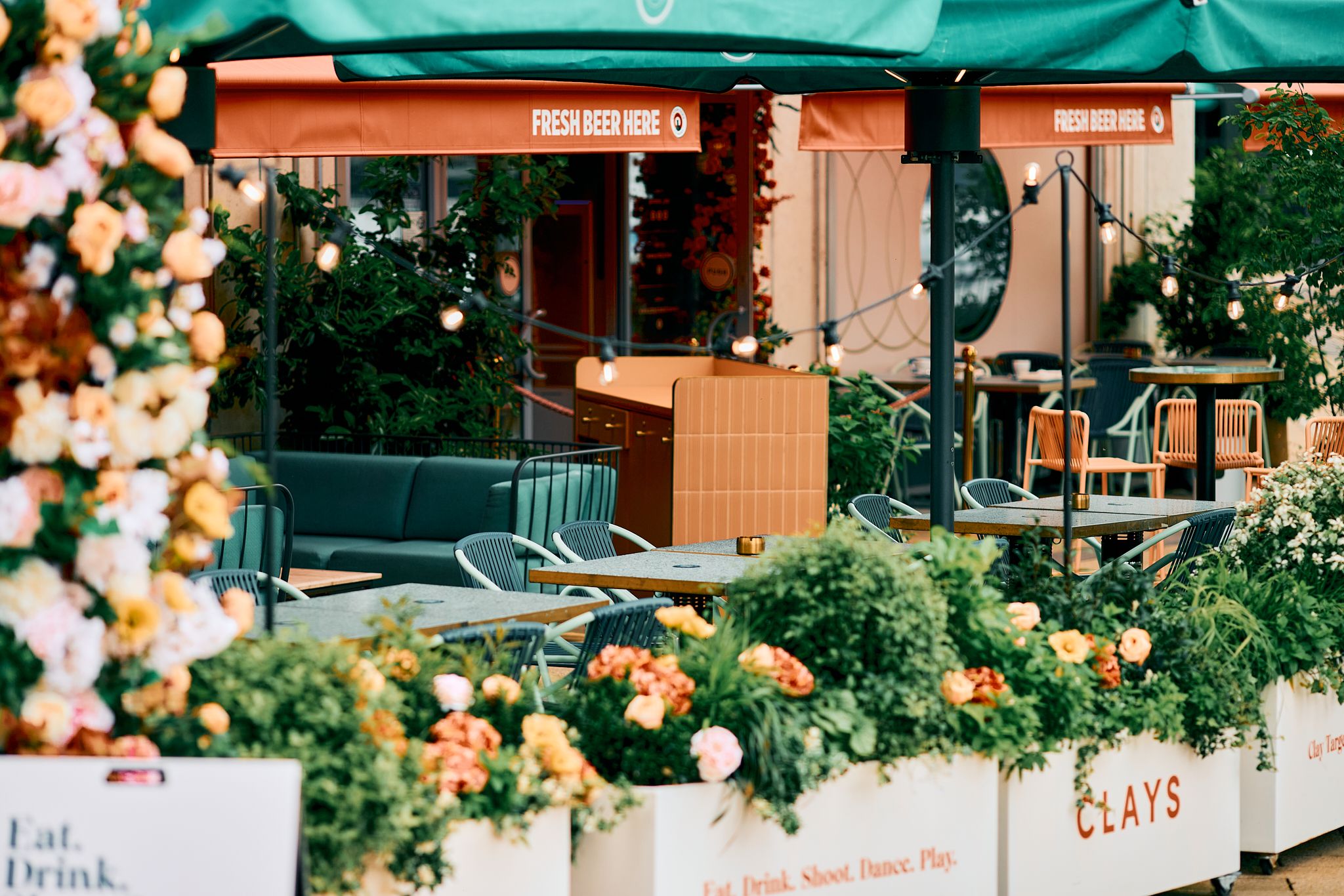 Vibrant outdoor event space at Clays Canary Wharf with lush flowers for summer gatherings.