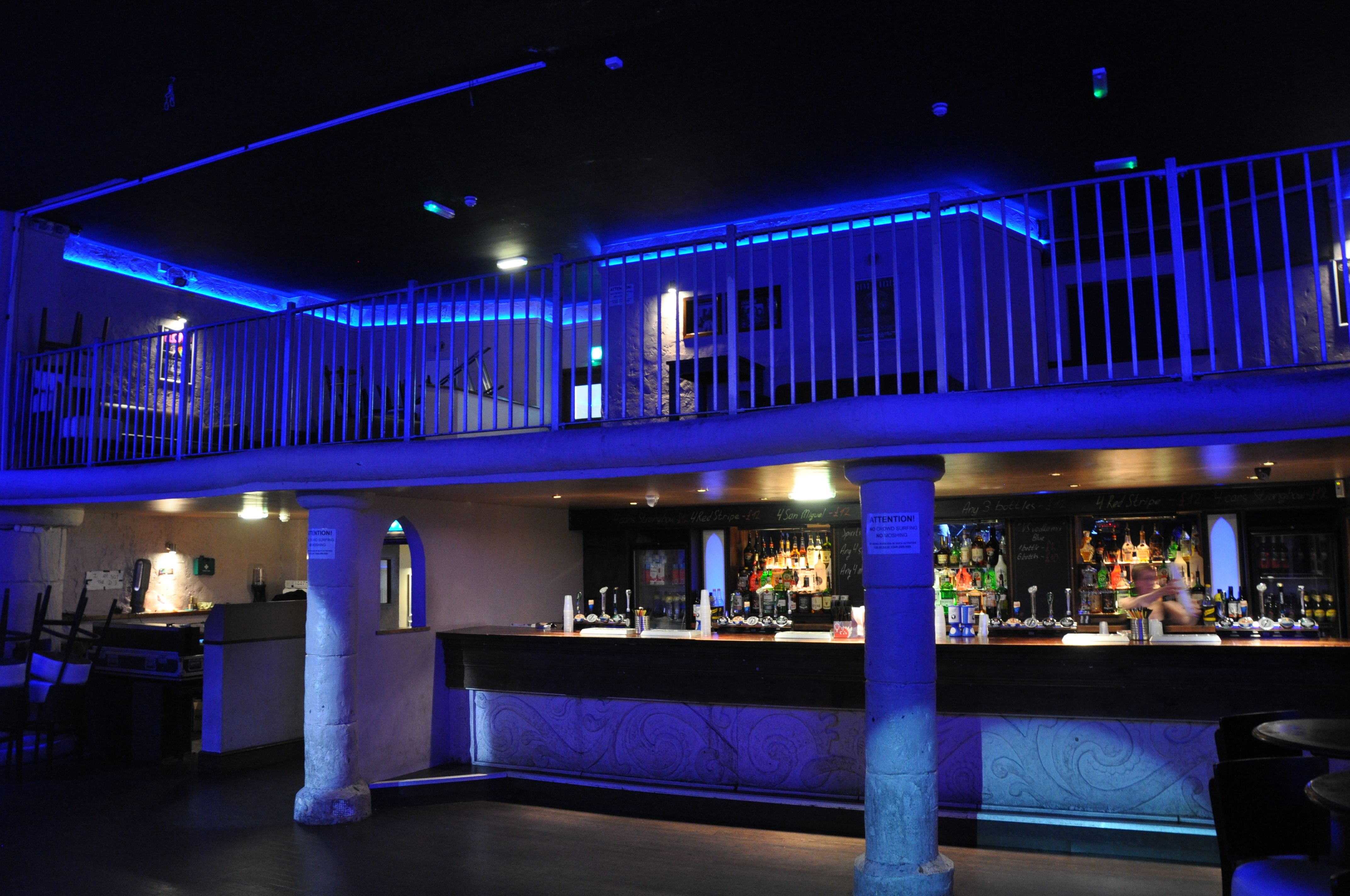 Stylish event space in The Globe Cardiff with modern bar and blue lighting for gatherings.