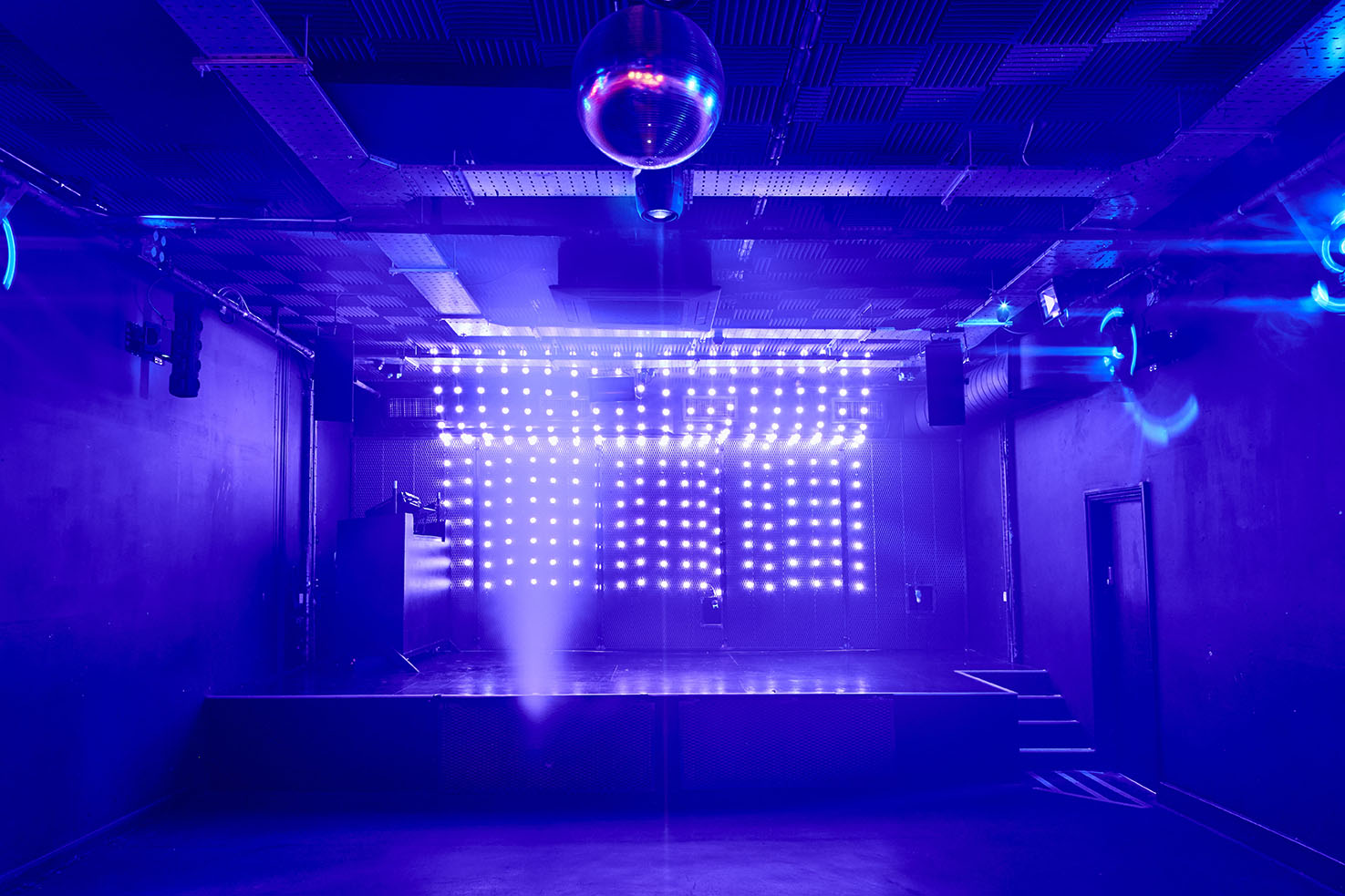 Modern event space at Camden Assembly with vibrant lighting and disco ball for parties.