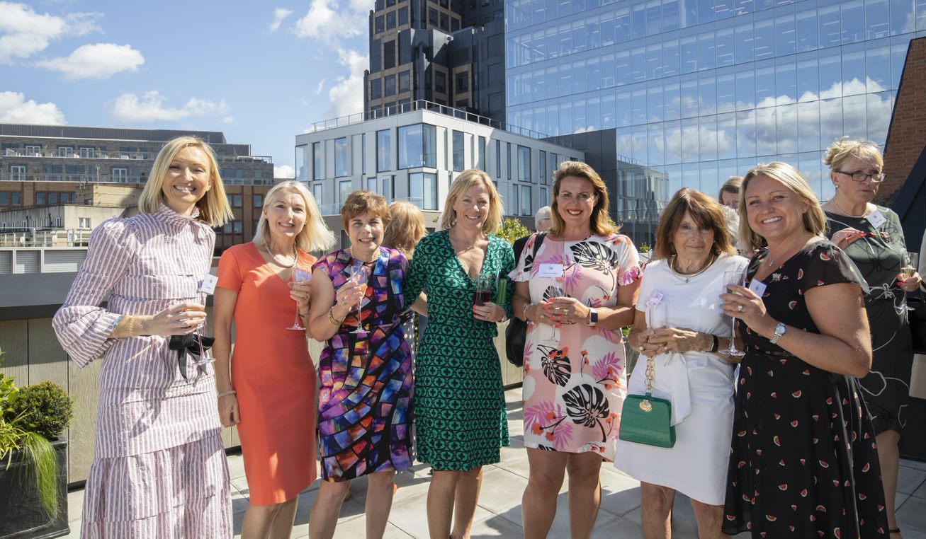 Vibrant outdoor networking event at 87 Barts Close with diverse women socializing.