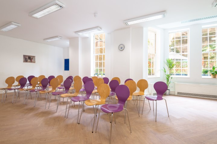 Bright meeting space with colorful chairs for workshops at Fitzrovia Community Centre.