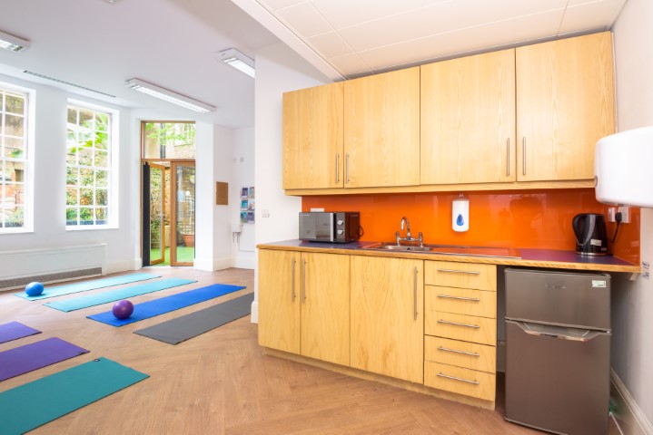 Owen Room at Fitzrovia Centre: modern kitchenette, yoga mats for wellness events.