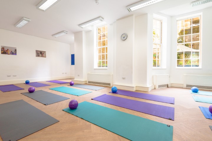 Spacious Owen Room with yoga mats for wellness workshops in Fitzrovia Community Centre.
