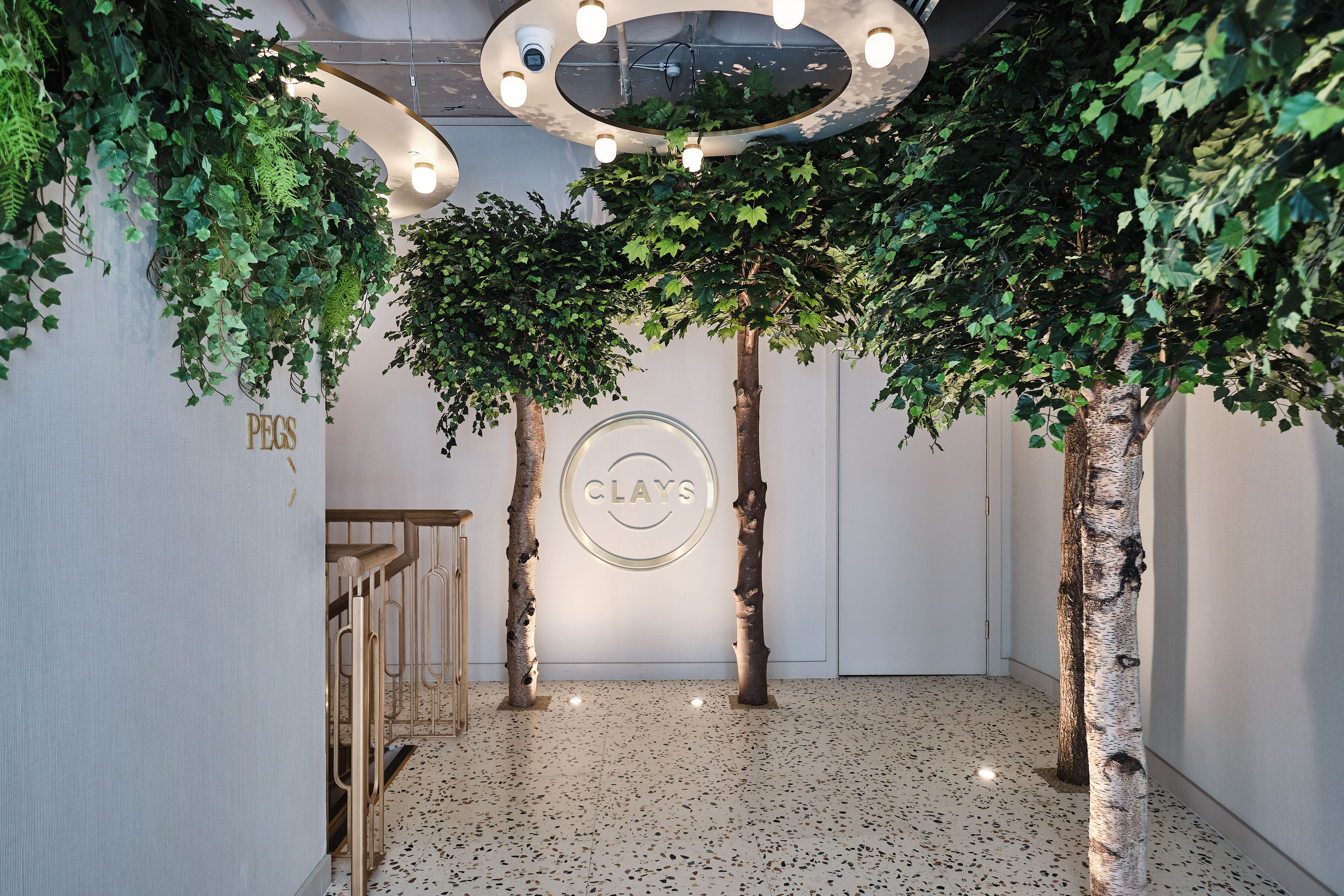 Stylish event space entrance with artificial trees, ideal for corporate meetings and gatherings.