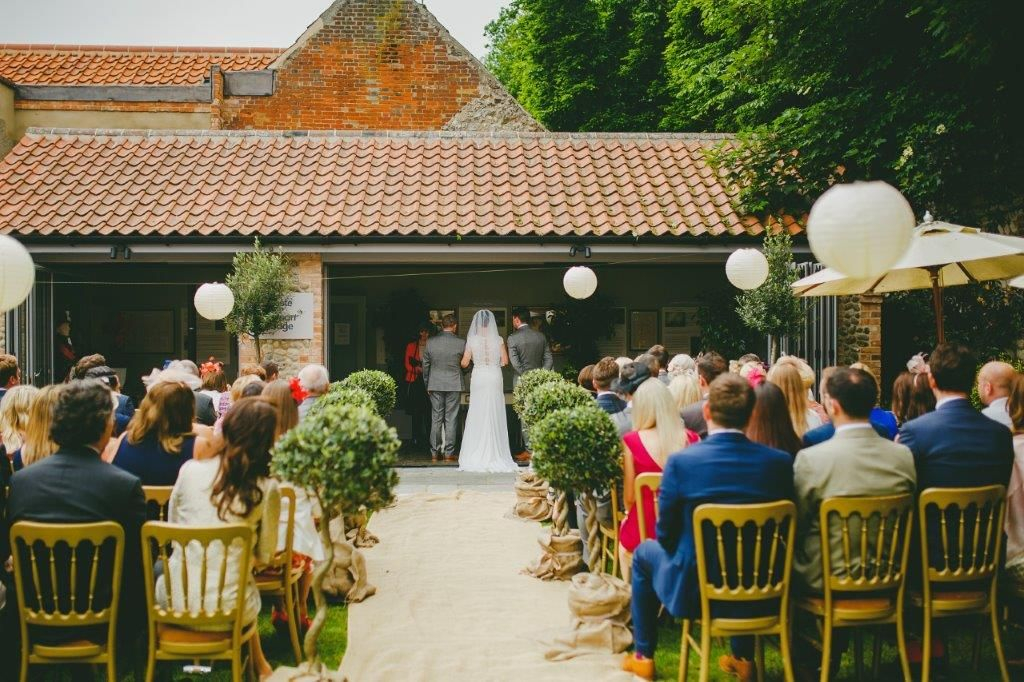 Outdoor wedding ceremony at The Hoste Arms with rustic decor and elegant seating.
