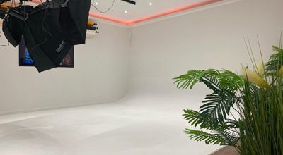 Photography studio with white backdrop, ideal for hybrid meetings and virtual events.