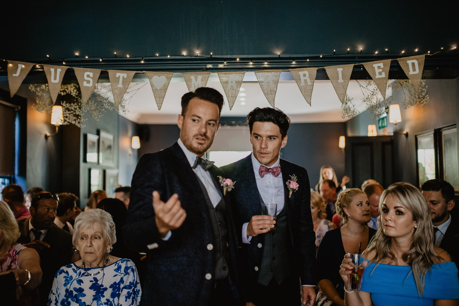 Stylish wedding reception in The Pembroke Suite with "Just Married" banner and diverse guests.