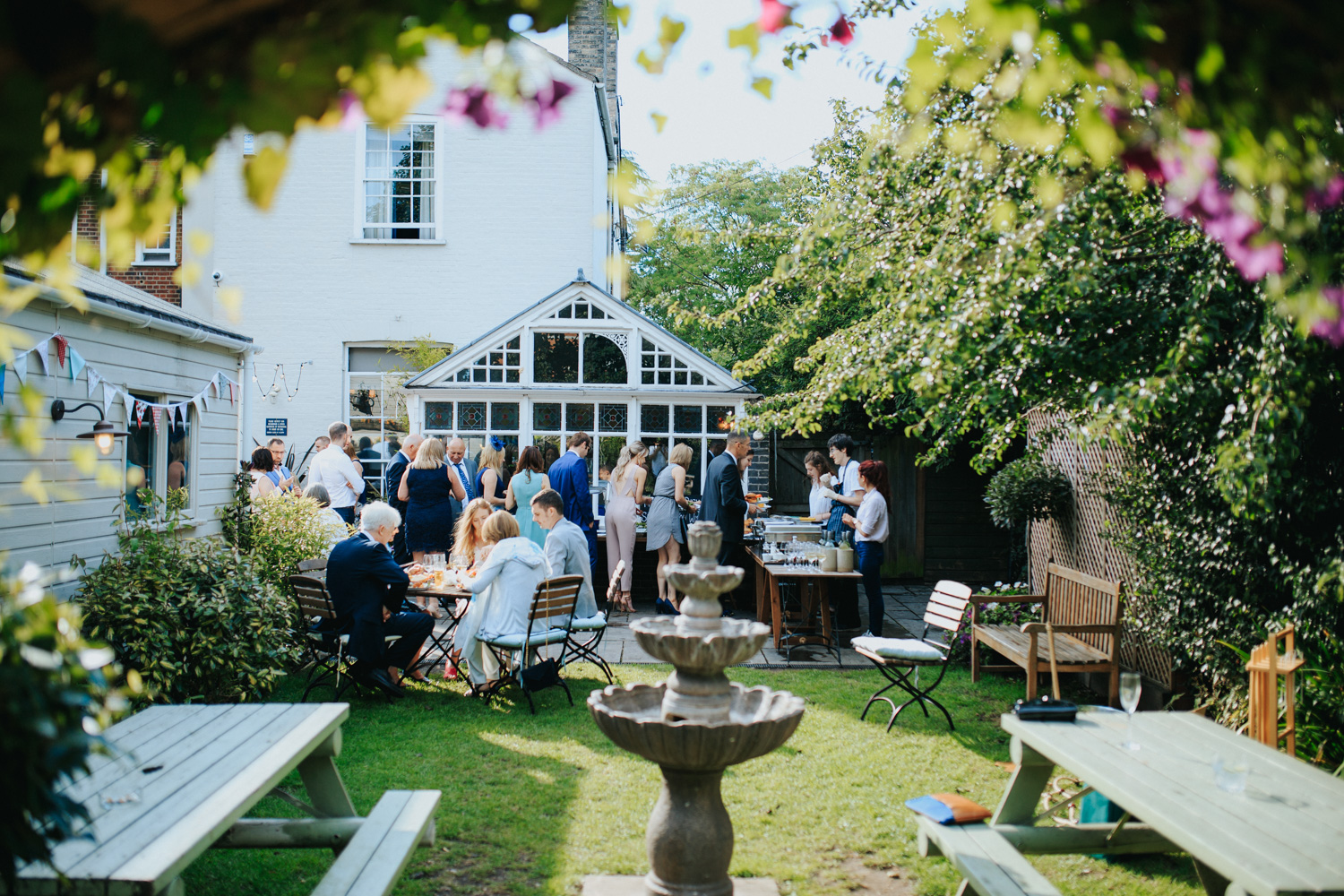 Charming outdoor event space with lush greenery and fountain at The Pembroke Suite.