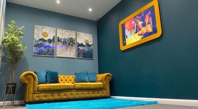 Stylish lounge area with yellow couch for networking events at Tribe Urban Studios.