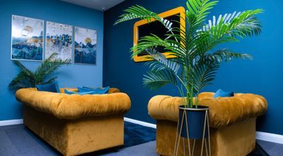 Stylish Lounge Studio with blue walls and yellow sofas for creative meetings.