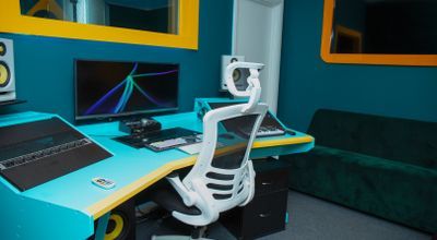 Modern music studio with ergonomic chair, ideal for virtual meetings and events.