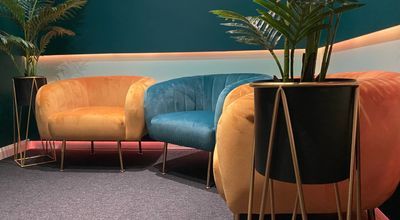 Stylish podcast studio lounge with vibrant orange and blue seating for networking events.