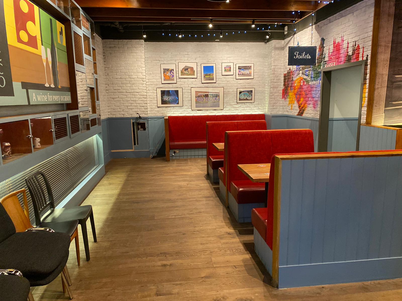 Cozy dining area at LDN Craft with red booths for corporate gatherings and networking events.