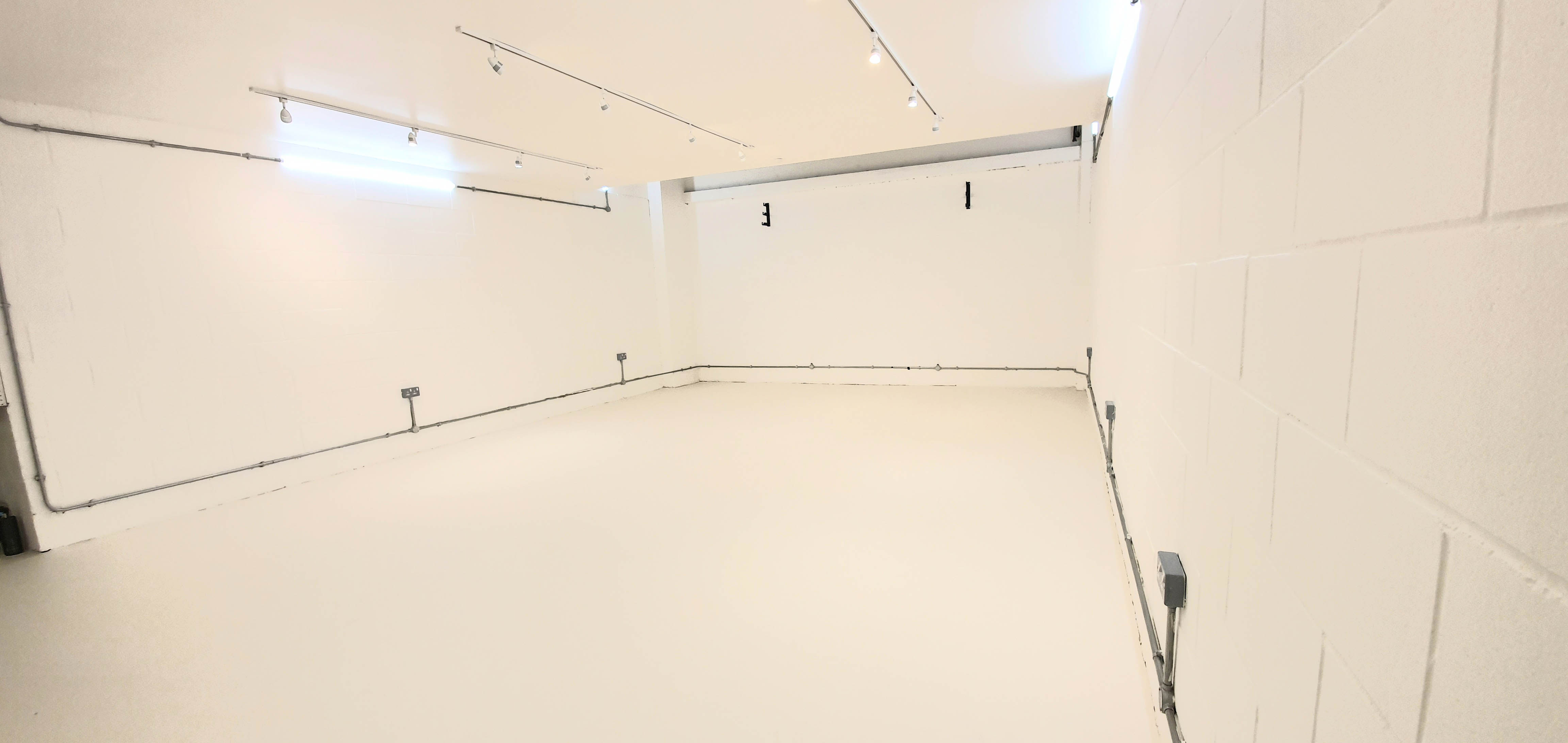 Versatile event space with clean white walls for meetings and workshops at Indra Studios.