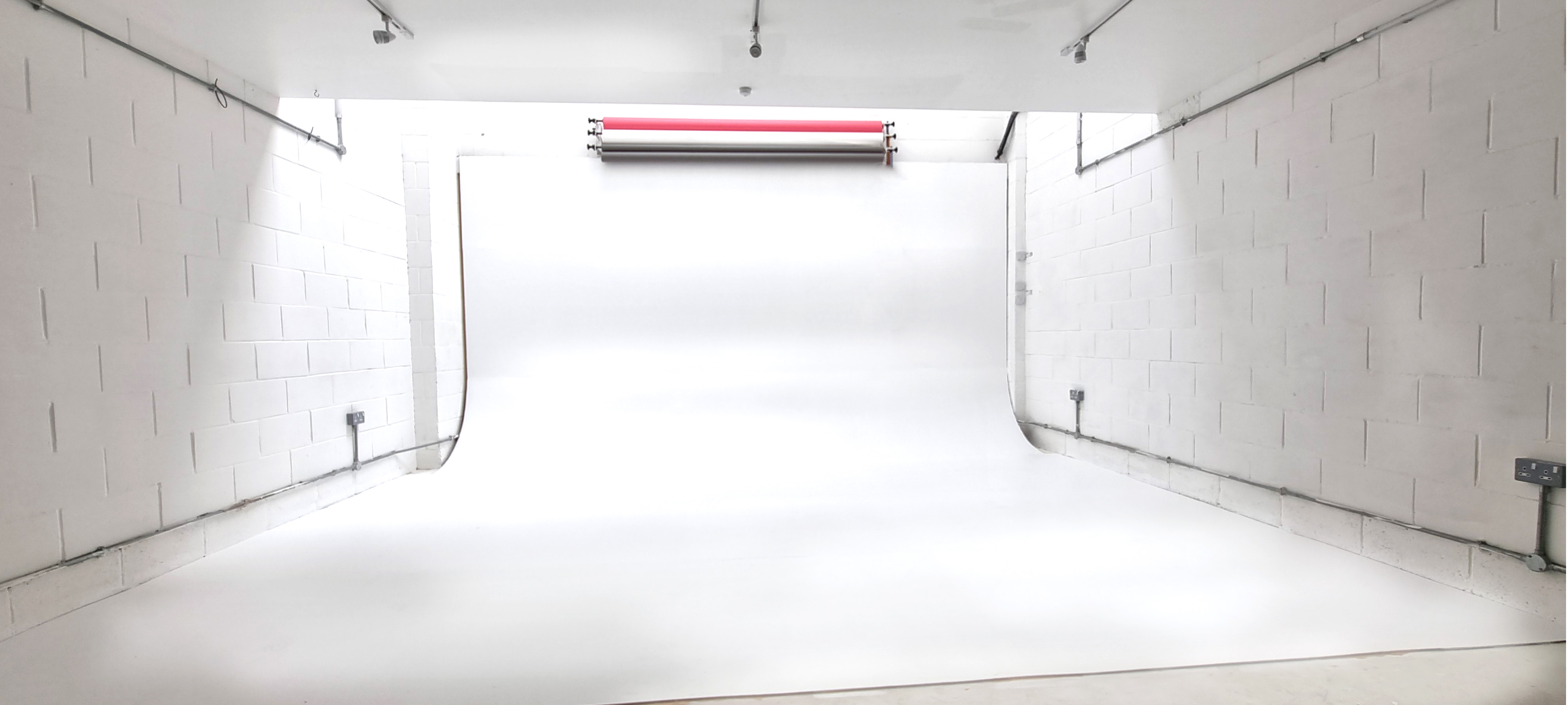 Minimalist photography studio with seamless white backdrop for events and meetings.